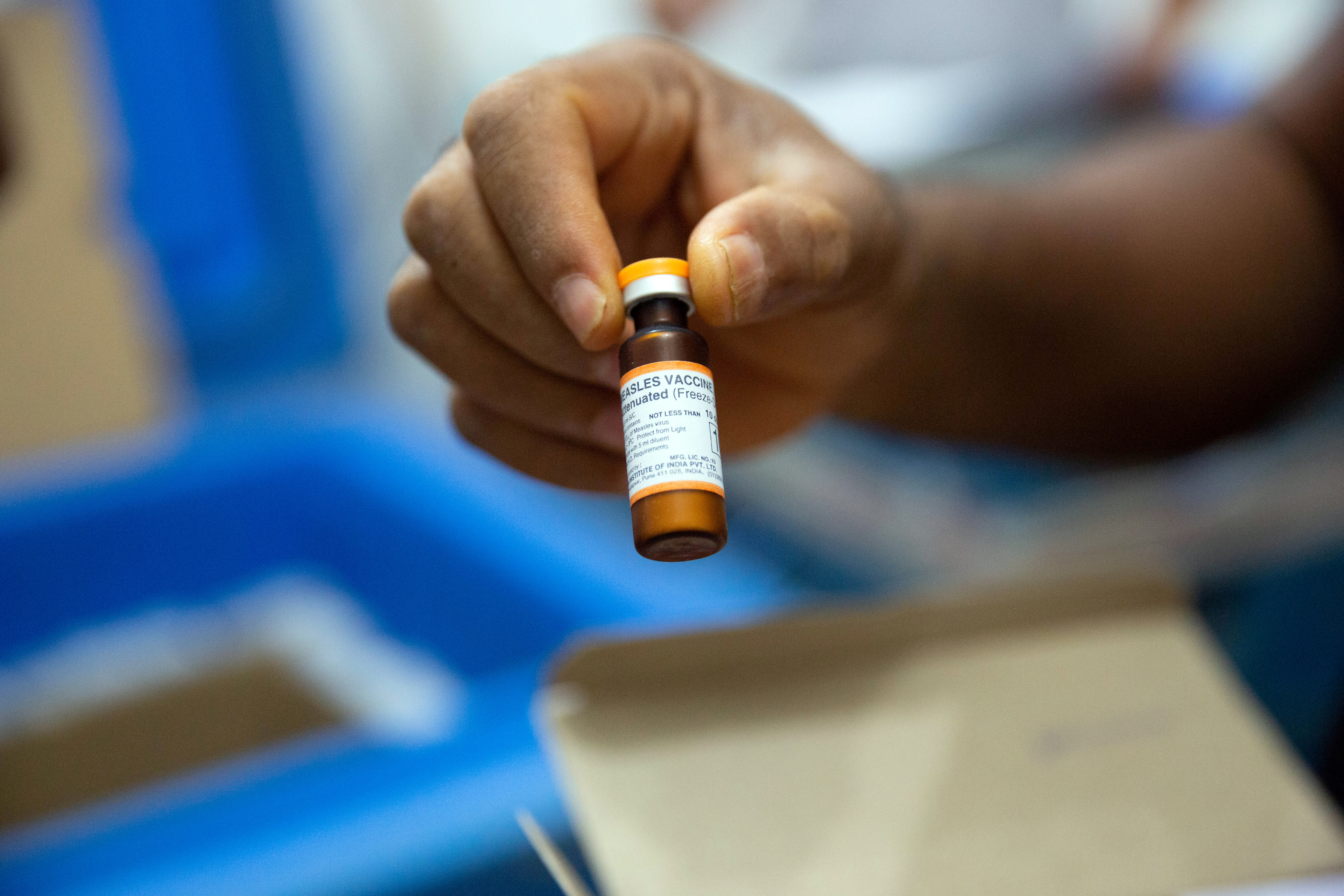 A vial of measles vaccine is checked at a field logistics base run by Doctors Without Borders in the town of Boso-Manzi in Mongala province