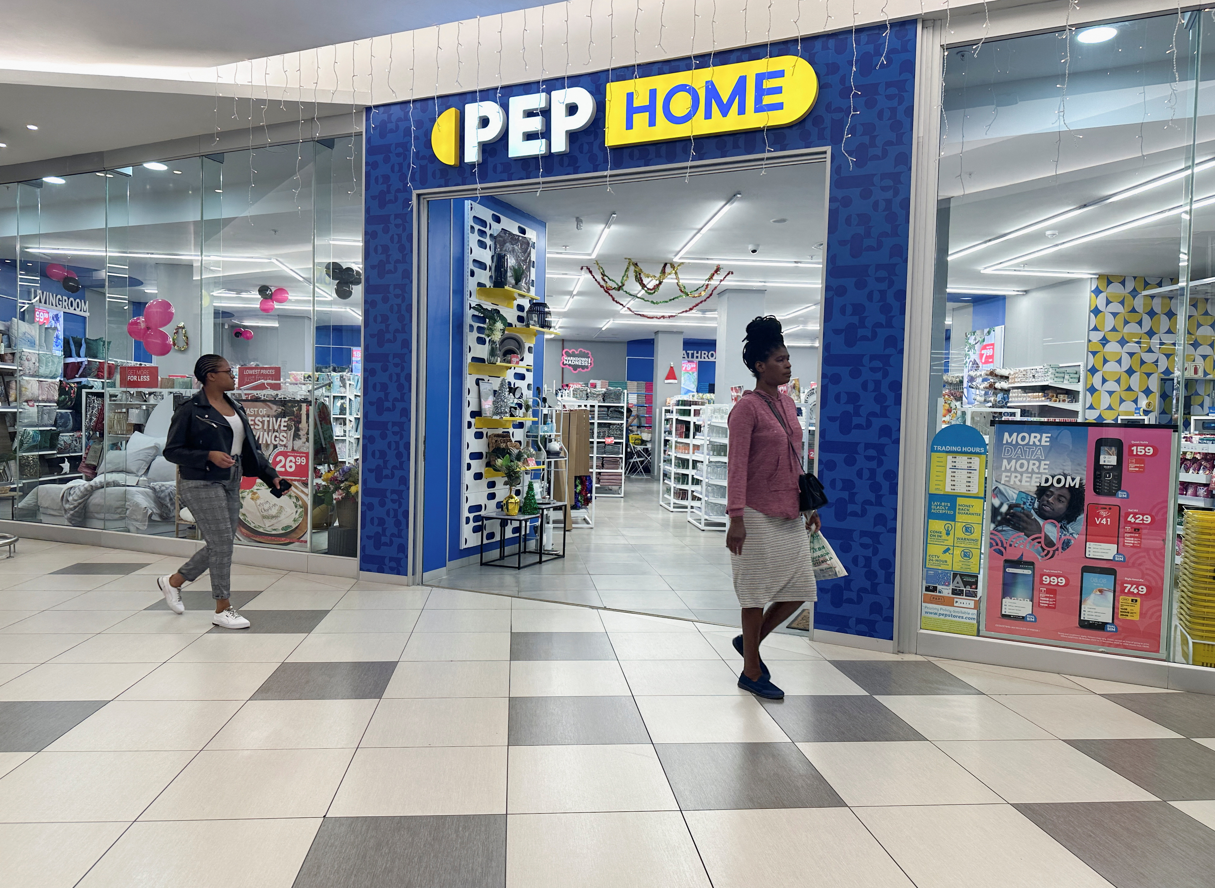 Women walk past a PEP Home store in Johannesburg