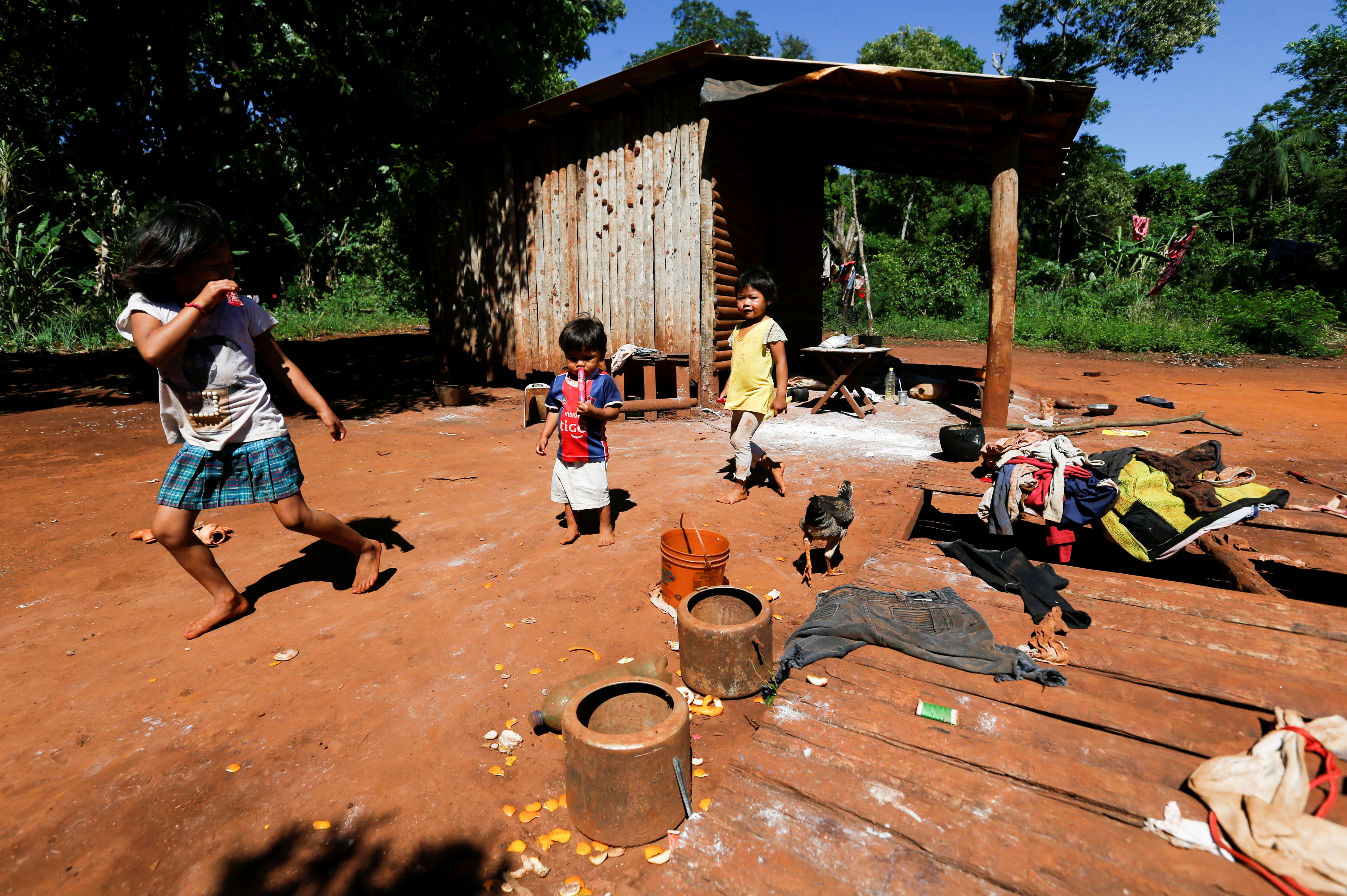Children member of the indigenous community Mby'a Guarani, who live from the hunting and fishing on the Parana River, play outside their house, at the Parque Nacional Moises Bertoni, in the city of Presidente Franco, Paraguay October 13, 2021. Picture taken October 13, 2021. REUTERS/Cesar Olmedo