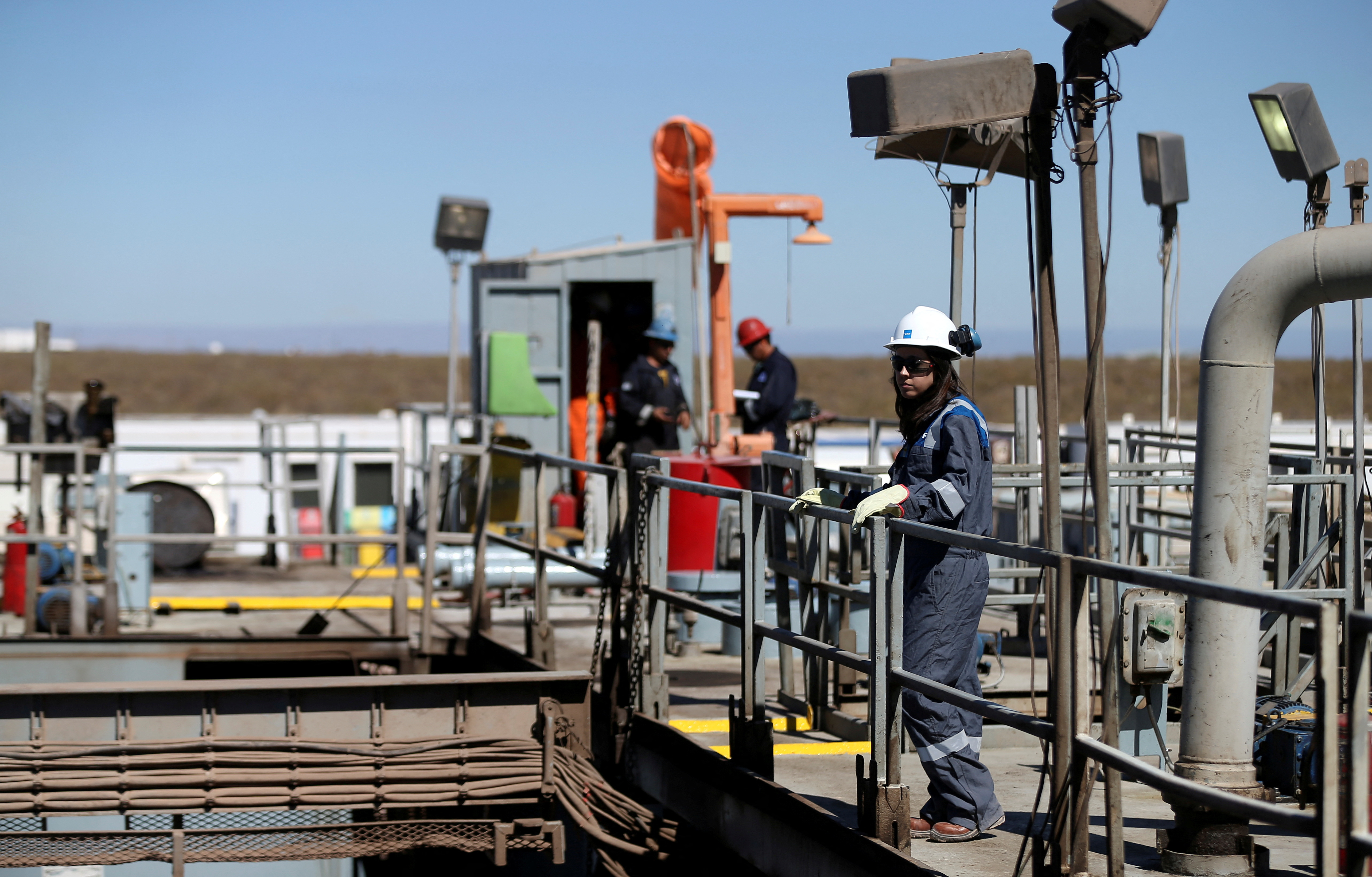 A worker looks on over a platform in a drilling rig at Vaca Muerta shale oil and gas drilling, in the Patagonian province of Neuquen