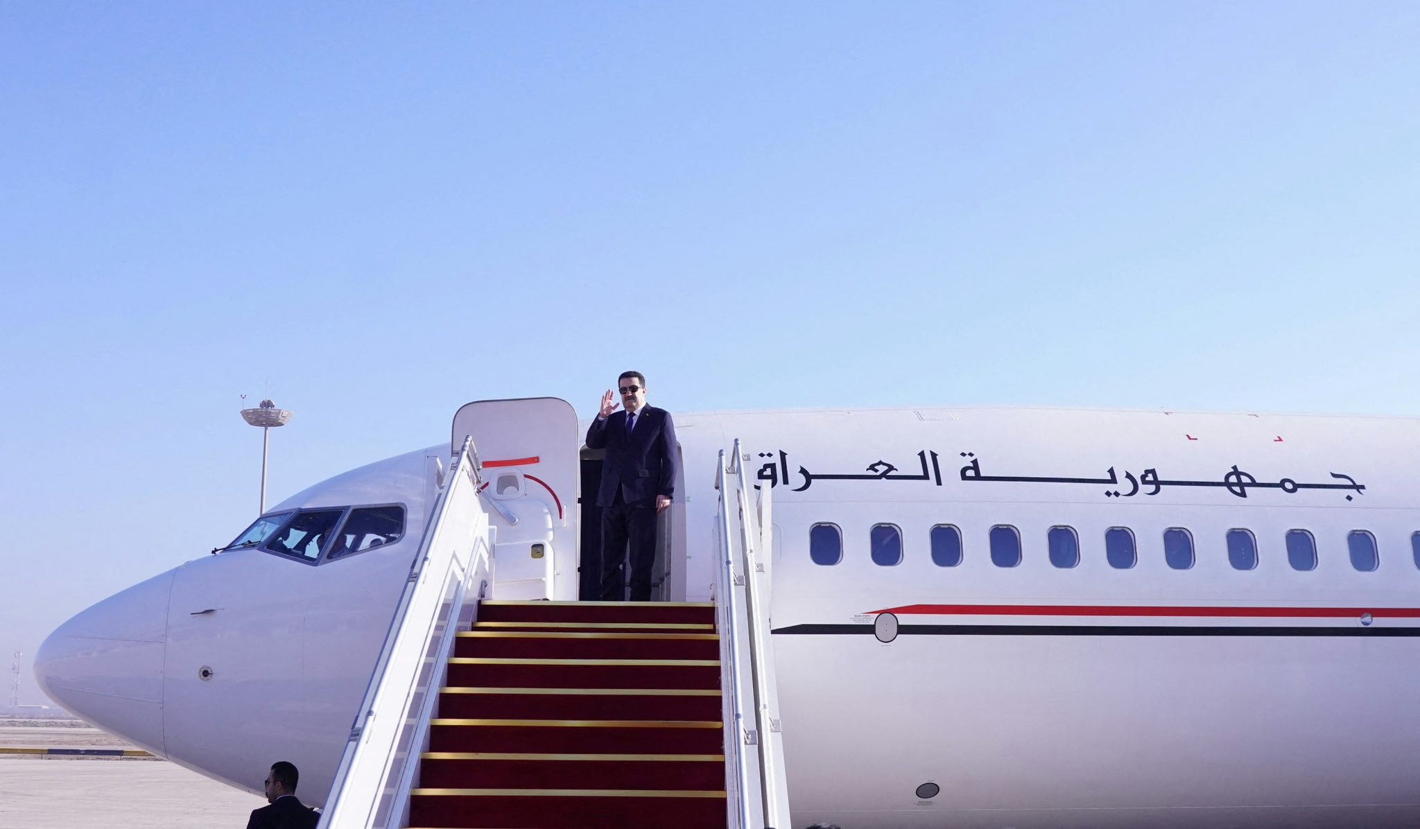 Iraqi Prime Minister Mohammed Shia al-Sudani boards a plane as he leaves for second Iraq conference in Amman, in Baghdad