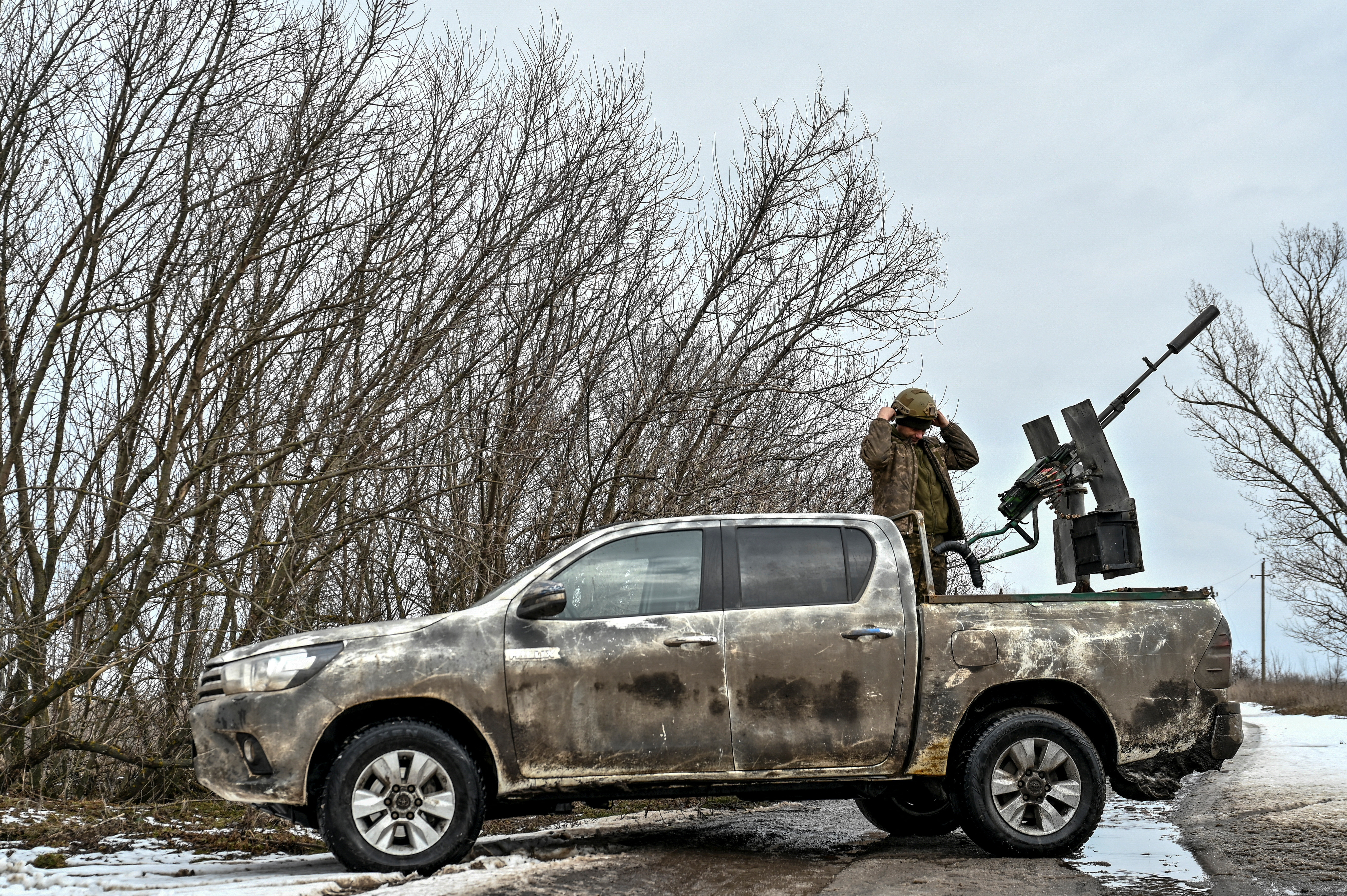 Ukrainian serviceman stands on a vehicle next to a machine gun in a frontline in Zaporizhzhia region
