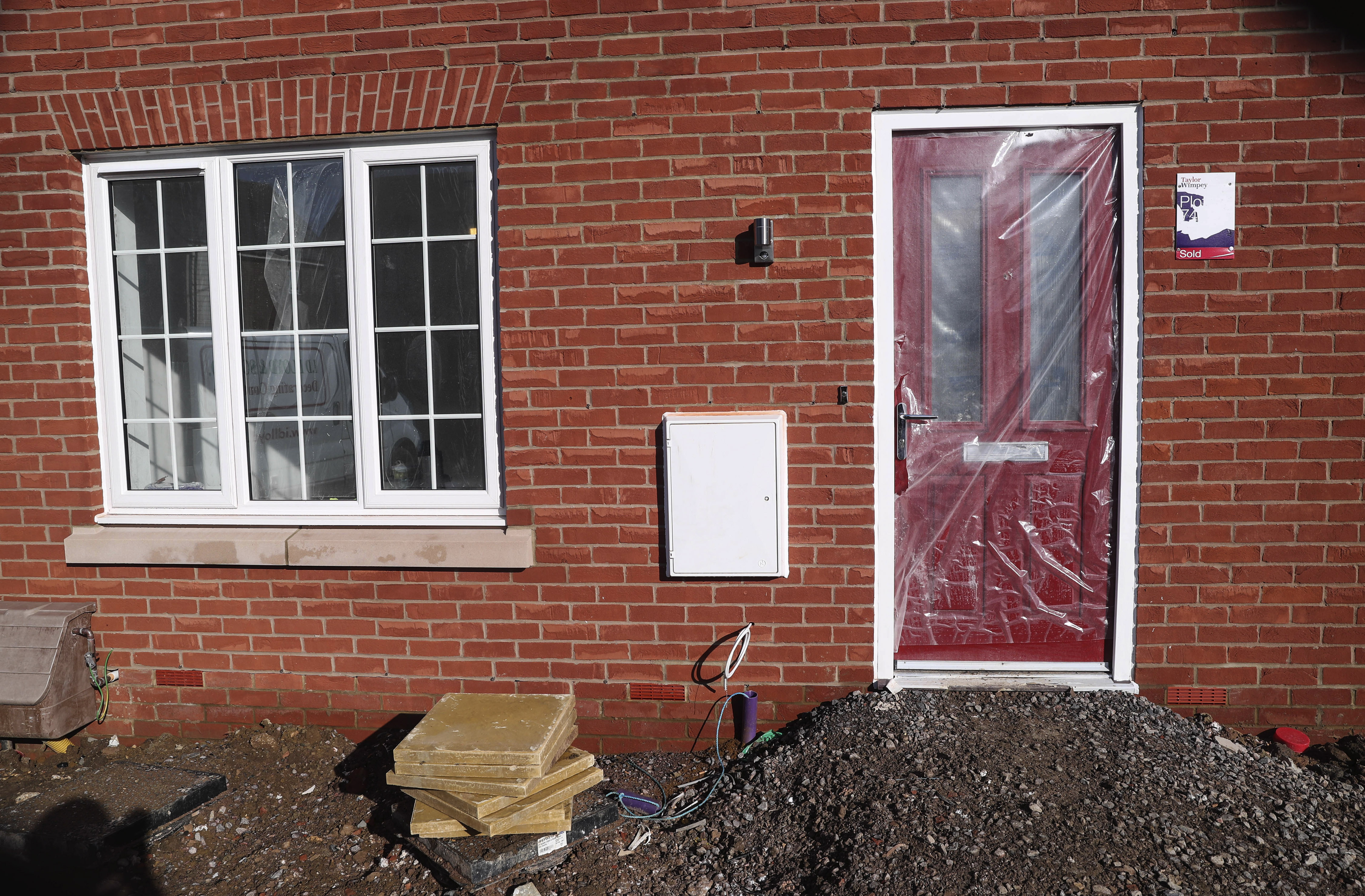 The door of a newly constructed Taylor Wimpey home is protected with plastic on a housing estate in Aylesbury