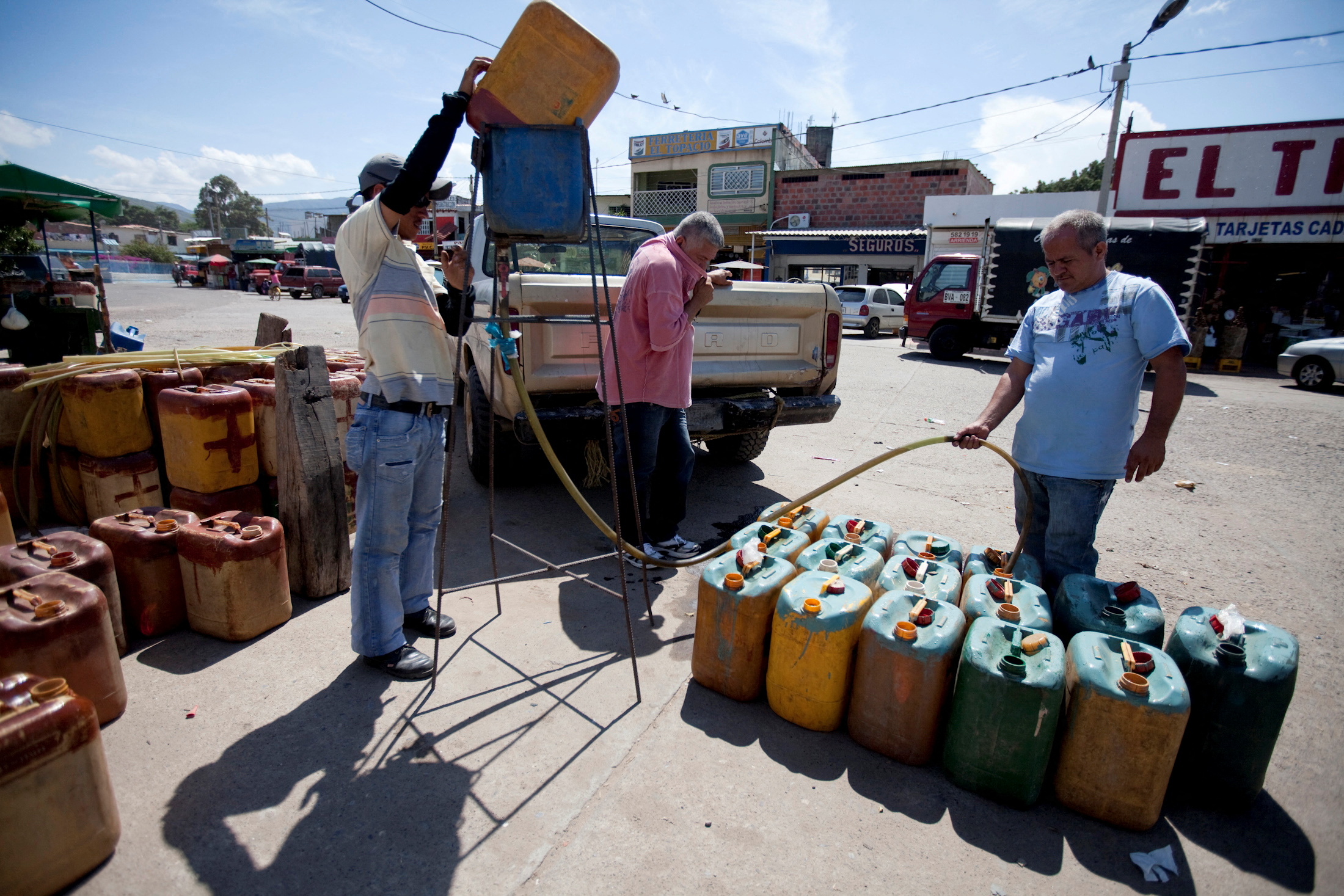Gasoline smugglers fills tanks with gasoline on the Colombian side at the border between San Antonio and Cucuta
