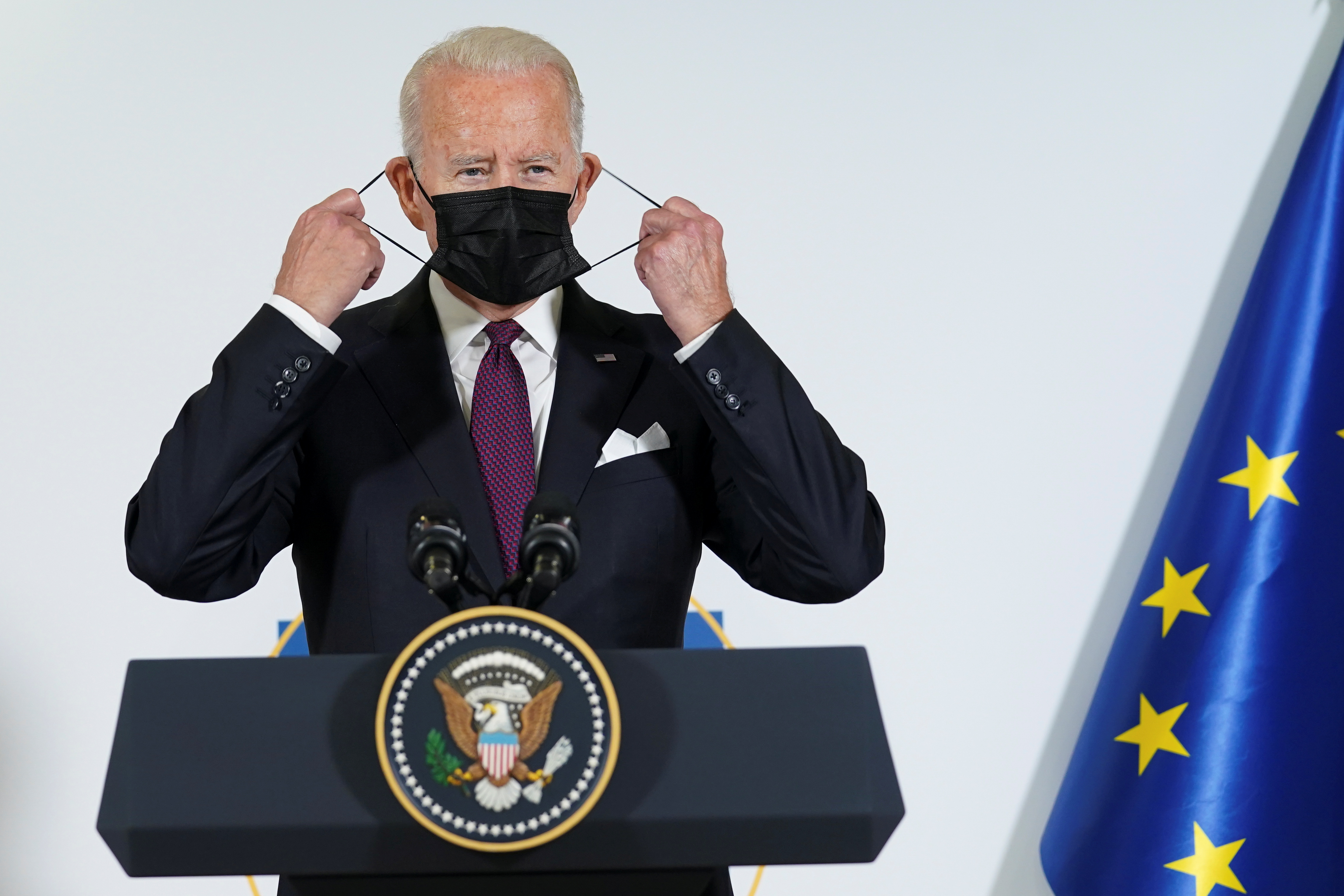 U.S. President Joe Biden adjusts his face mask as he and European Commission's President Ursula von der Leyen (not pictured) make a joint statement to speak about steel and aluminium tariffs, on the sidelines of the G20 leaders' summit in Rome, Italy October 31, 2021. REUTERS/Kevin Lamarque