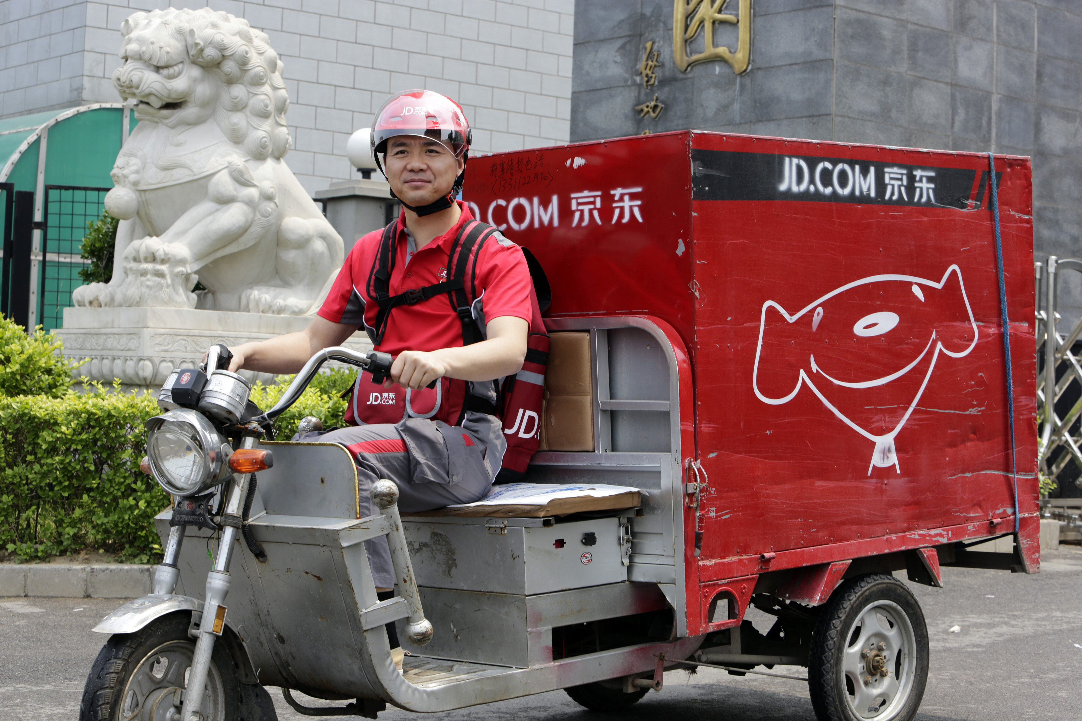Liu, CEO and founder of China's e-commerce company JD.com, rides an electric tricycle as he makes a delivery run in Beijing