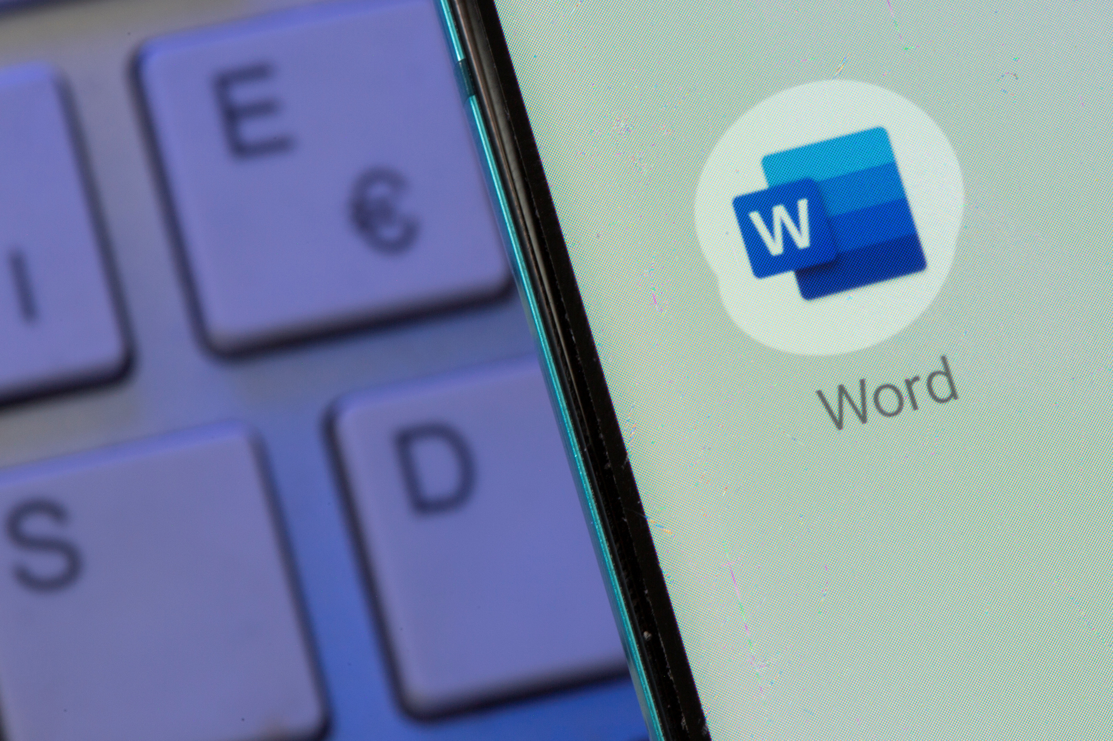 La aplicación Microsoft Word se ve en el teléfono inteligente colocado en el teclado en esta ilustración tomada