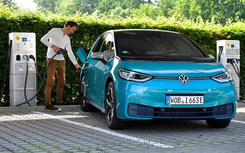 A man charges an electric ID. 3 car during a media event at German carmaker Volkswagen's so-called glass manufactory in Dresden, Germany, June 8, 2021. REUTERS/Matthias Rietschel/File Photo