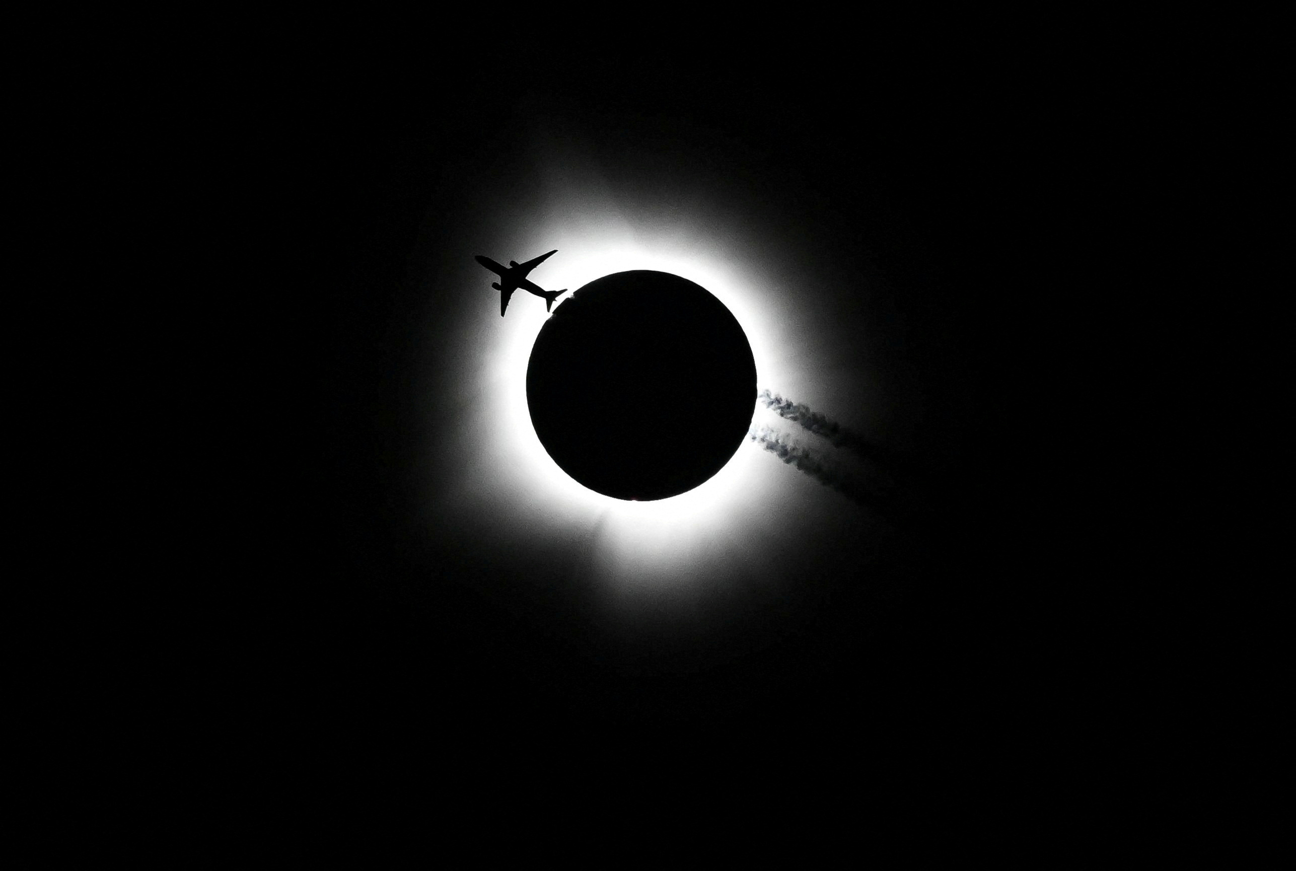 An airplane passes near the total solar eclipse in Bloomington