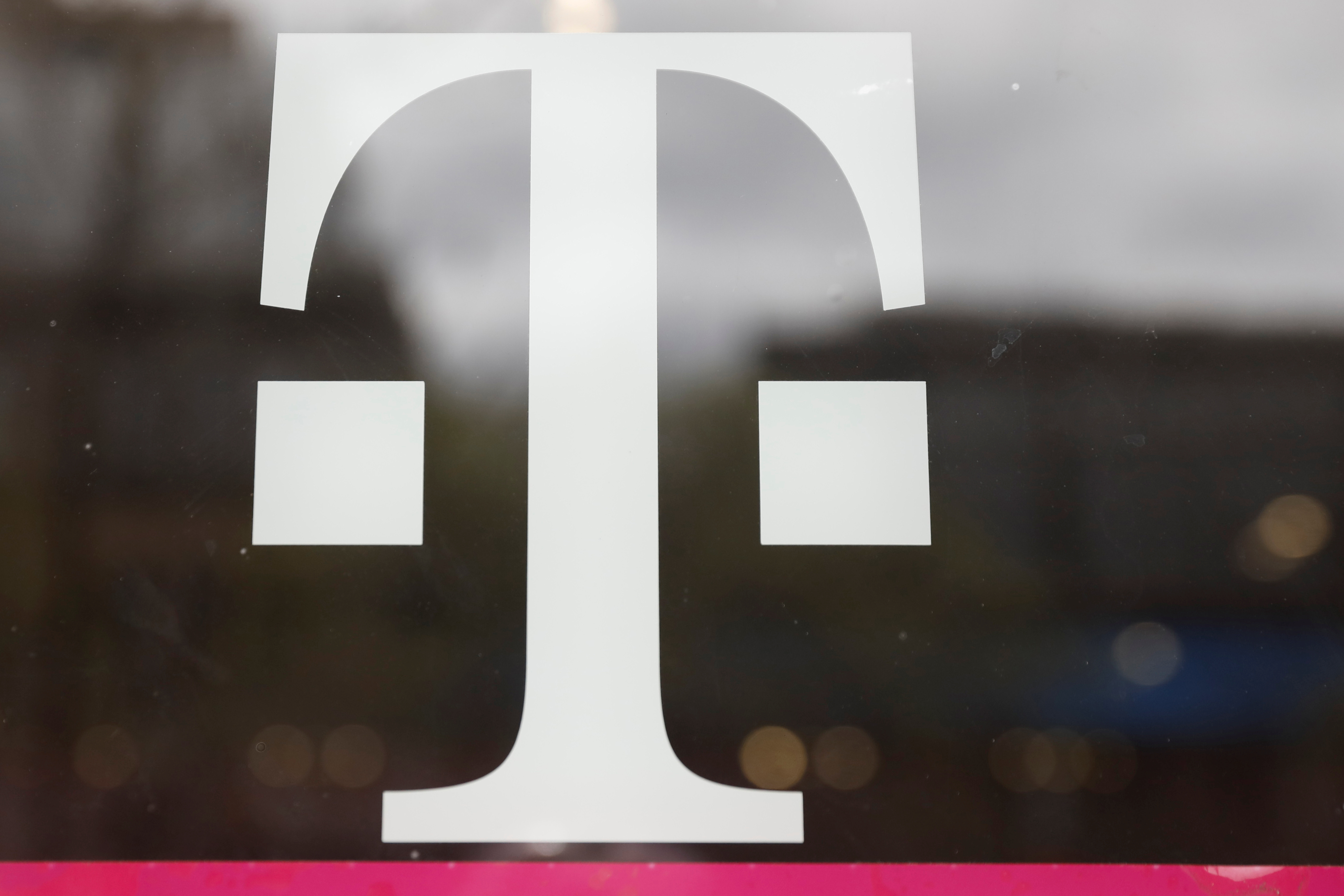 A T-Mobile logo is seen on the storefront door of a store in Manhattan