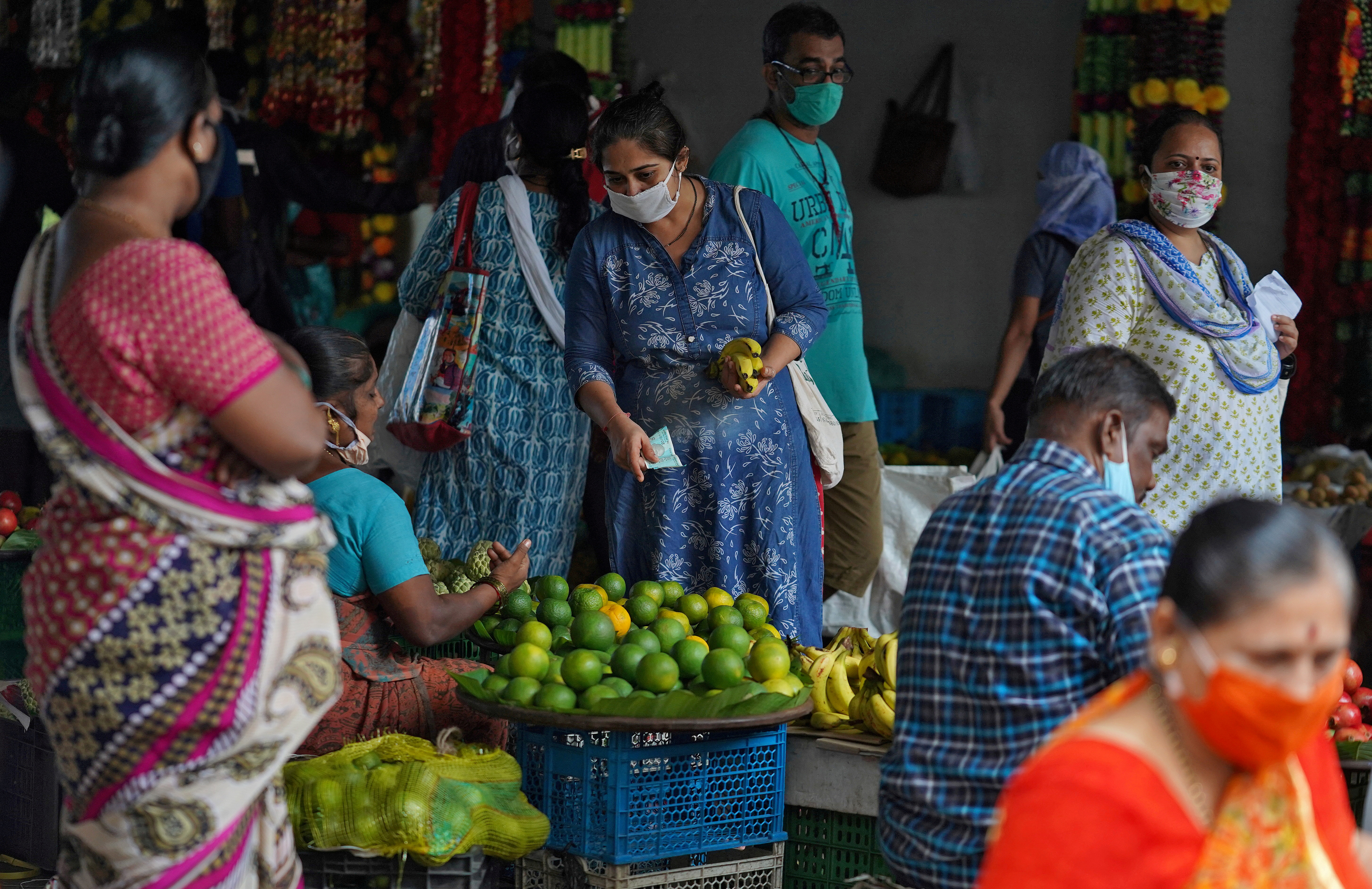 A woman wearing a protective face mask buys fruit in a market, amidst the spread of the coronavirus disease (COVID-19) in Mumbai, India, August 20, 2020. REUTERS/Hemanshi Kamani/File Photo