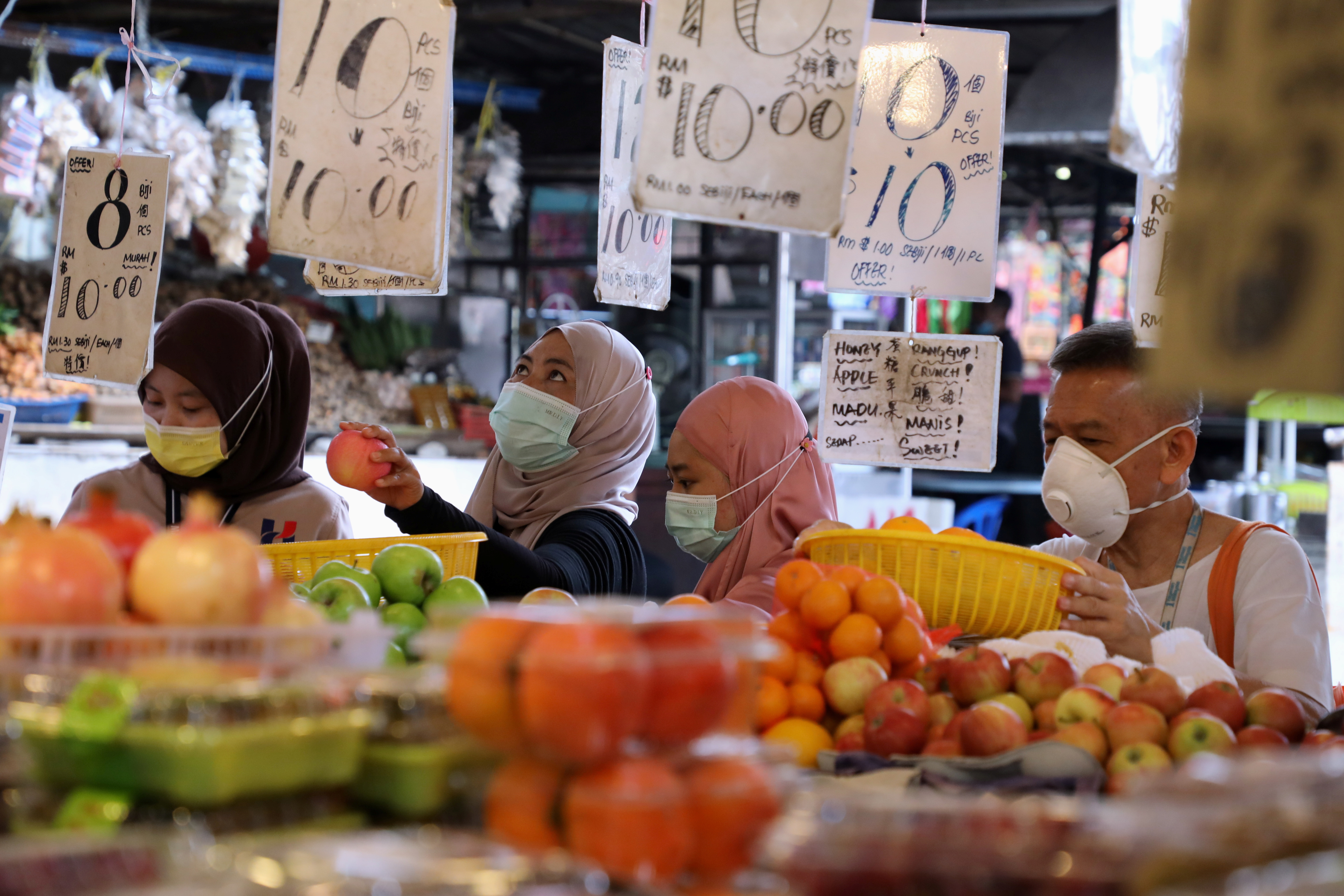 Shoppers wearing protective masks shop at a market, amid the coronavirus disease (COVID-19) outbreak in Kuala Lumpur