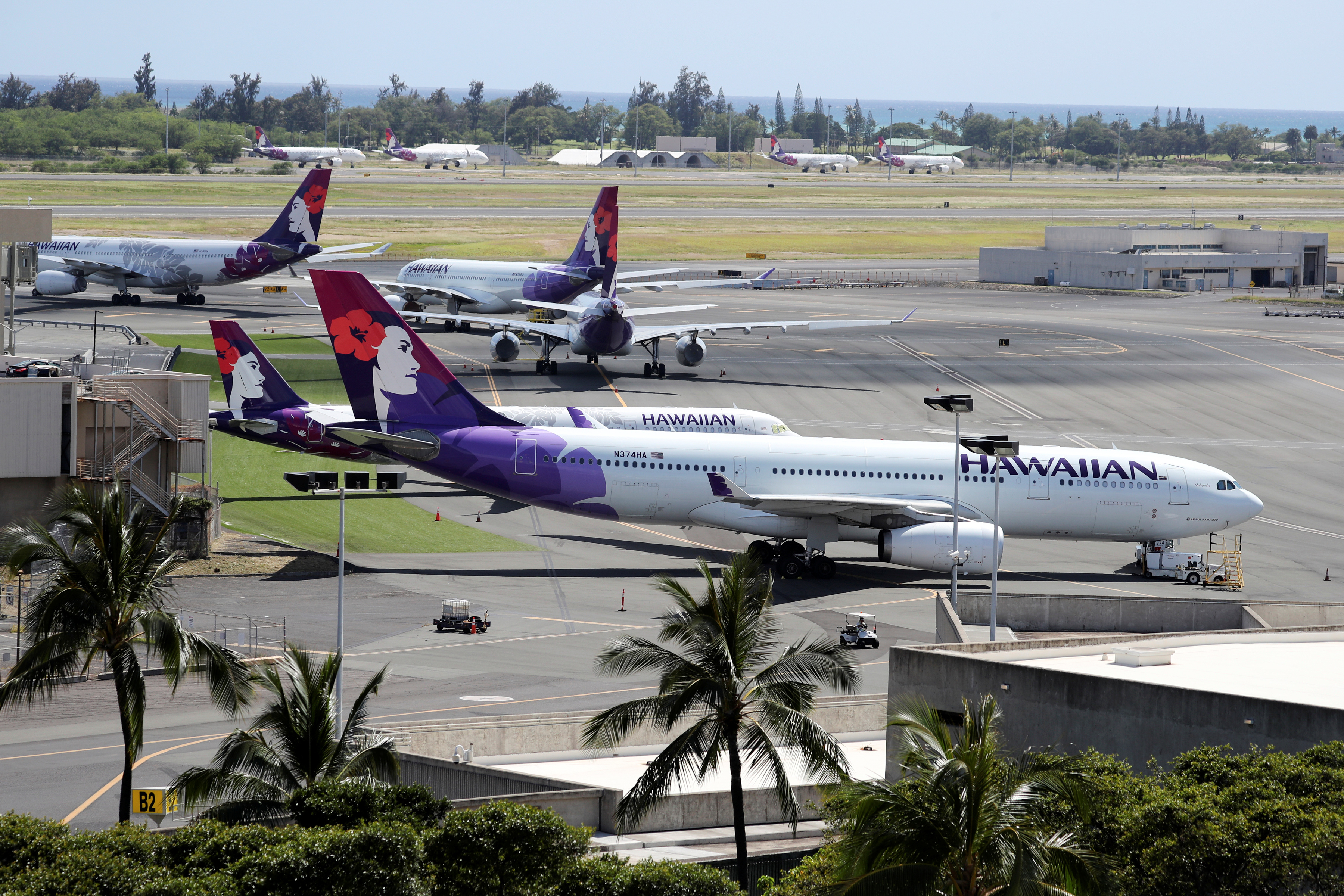 Hawaiian Airlines airplanes sit idle on the runway at the Daniel K. Inouye International Airport in Honolulu
