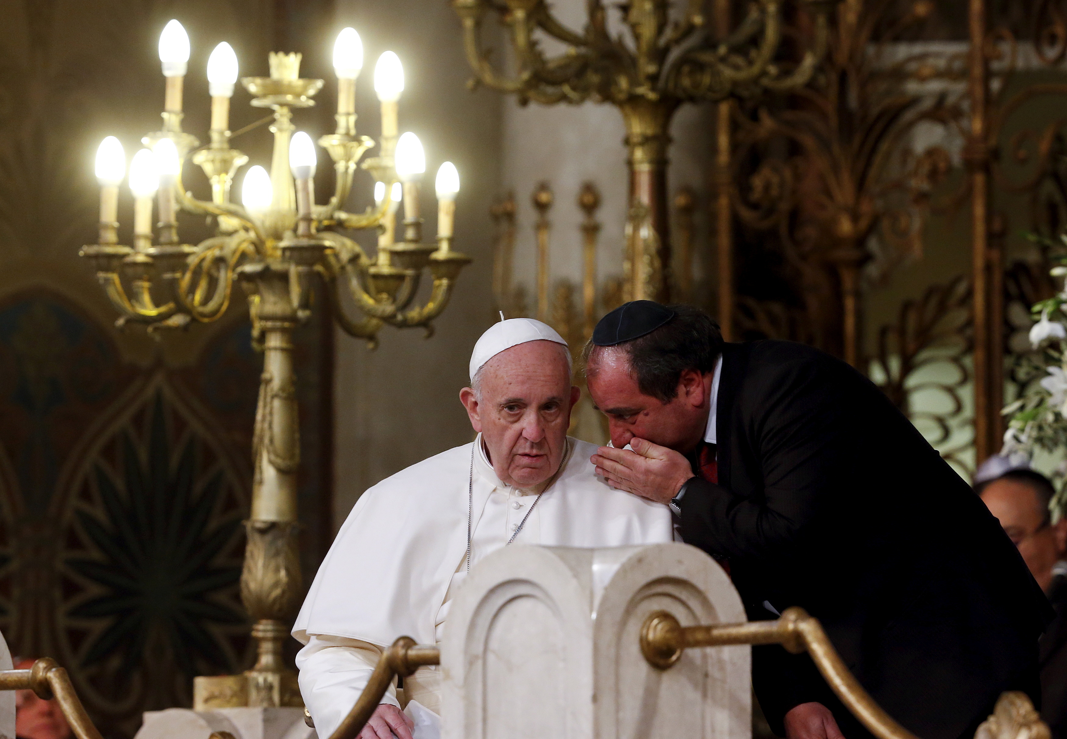 Pope Francis listens to a member of Jewish community during his visit at Rome's Great Synagogue