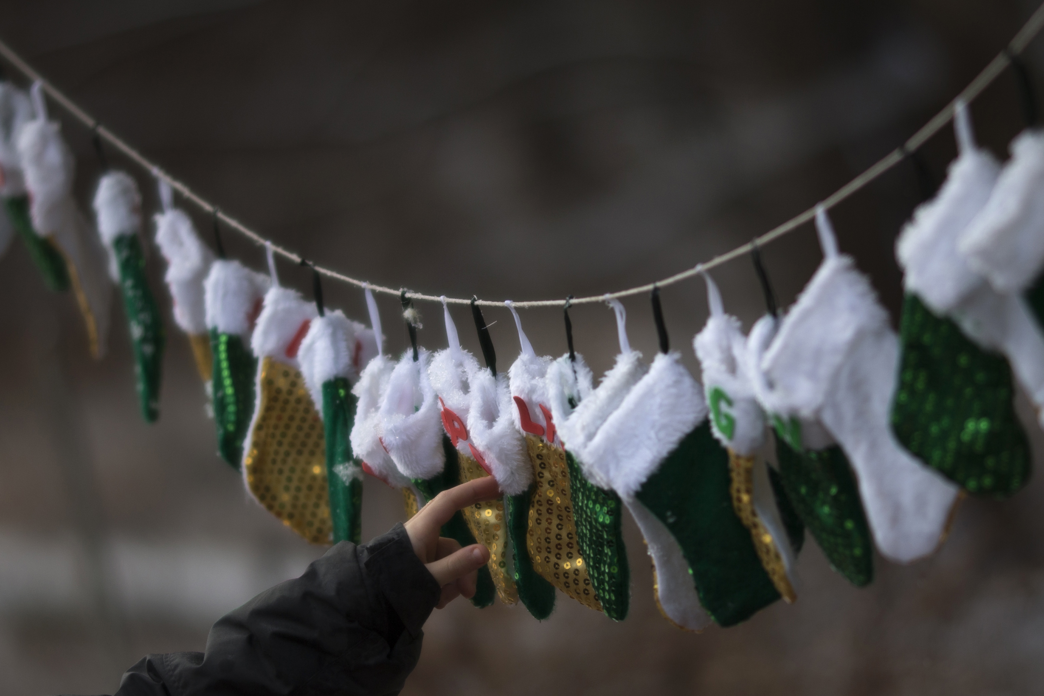 A boy touches stockings, representing those killed in the December 14 shootings at Sandy Hook Elementary School, on Christmas morning in Sandy Hook Village in Newtown, Connecticut