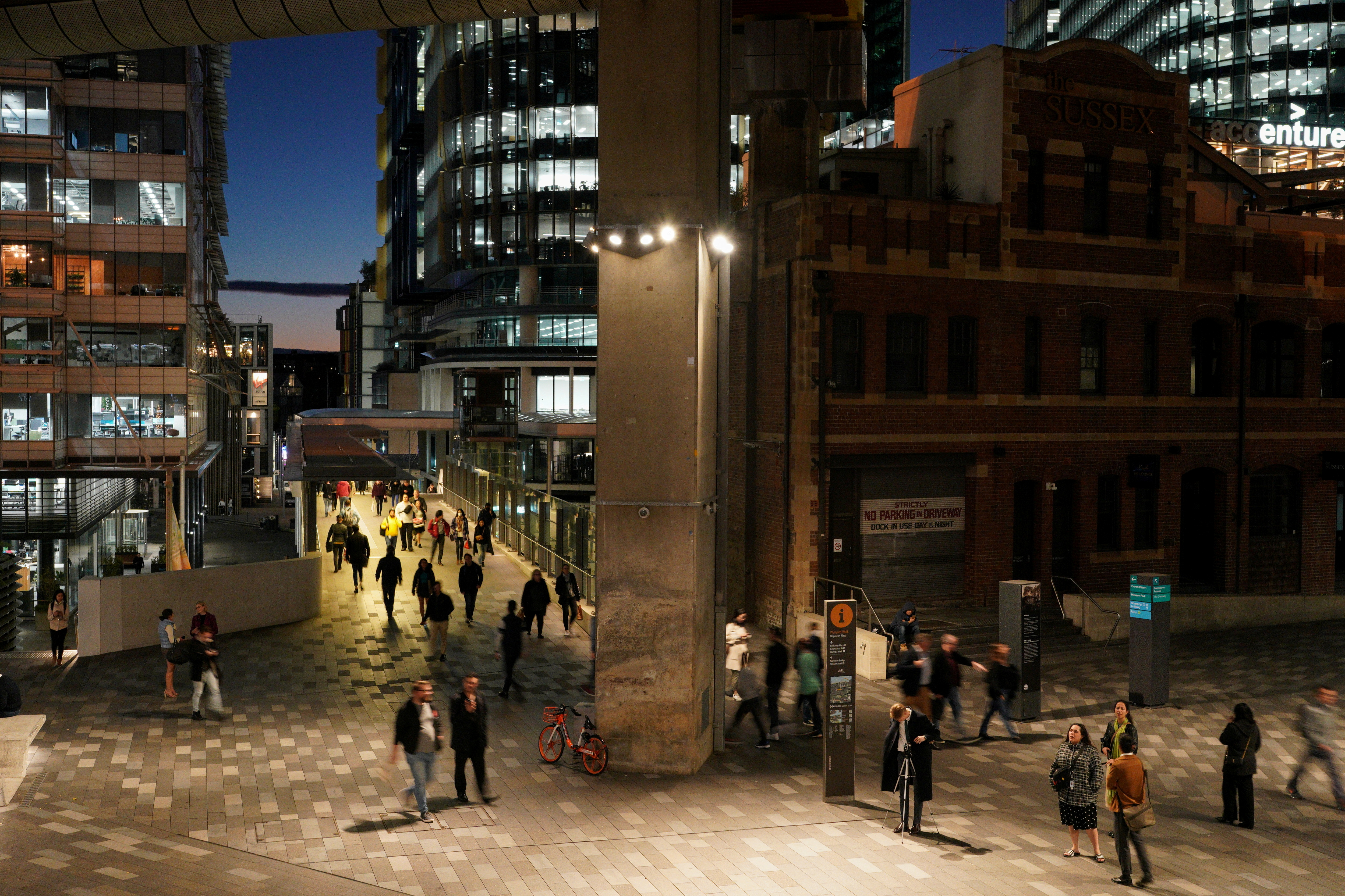 People walk through the Central Business District (CBD) at dusk in Sydney