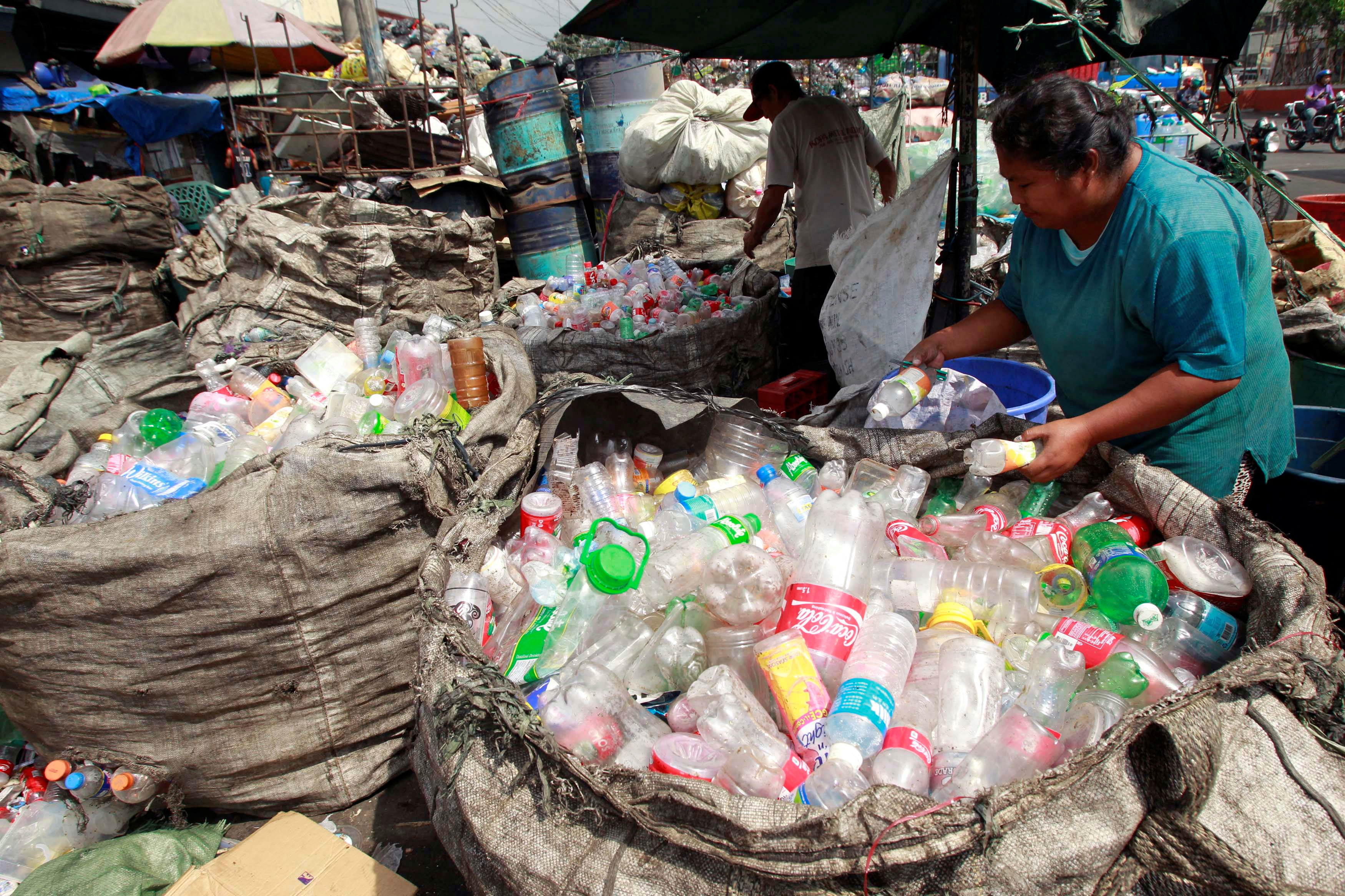 People sort through plastic bottles in Manila