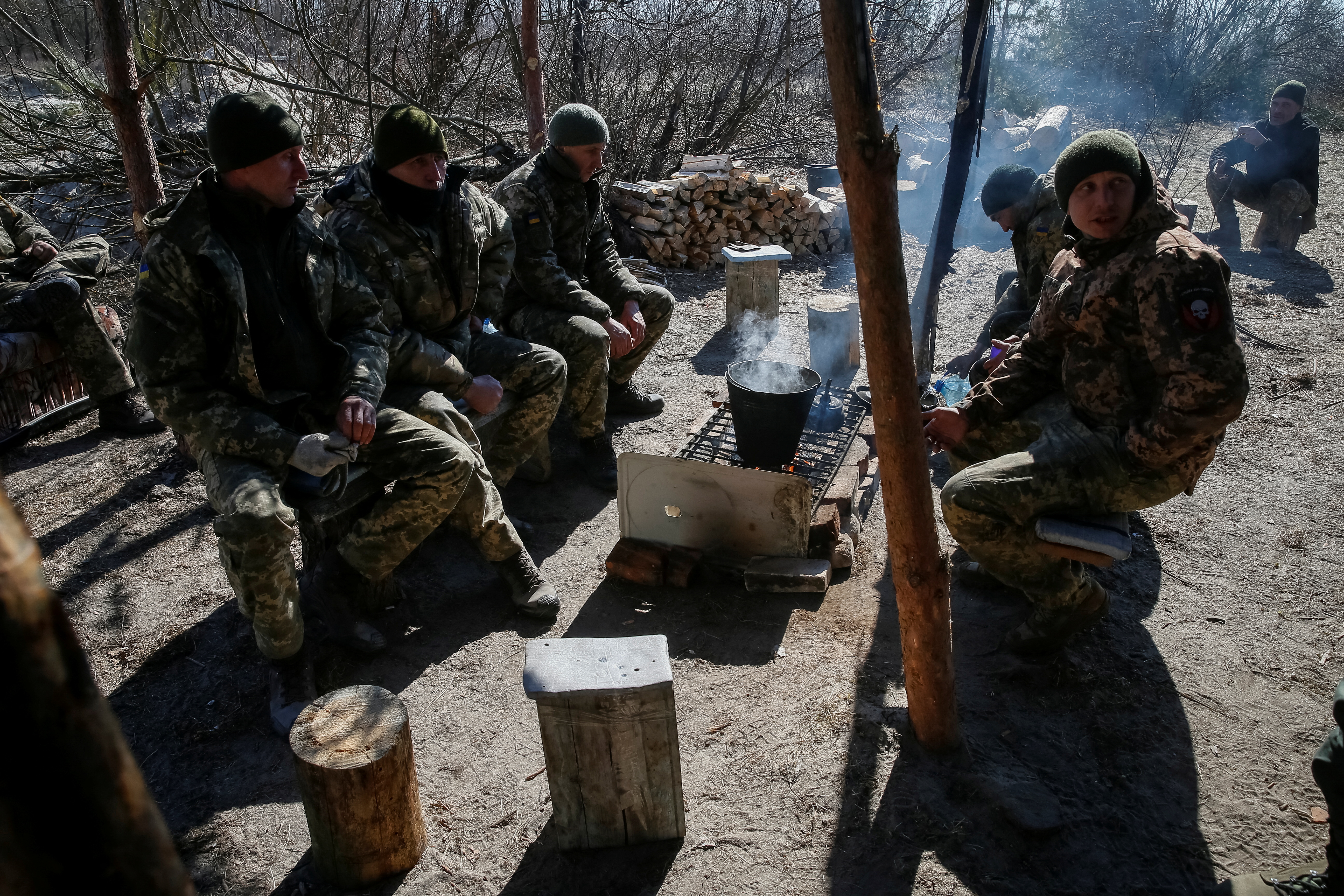 Ukrainian service members rest on the front line in the north Kyiv region