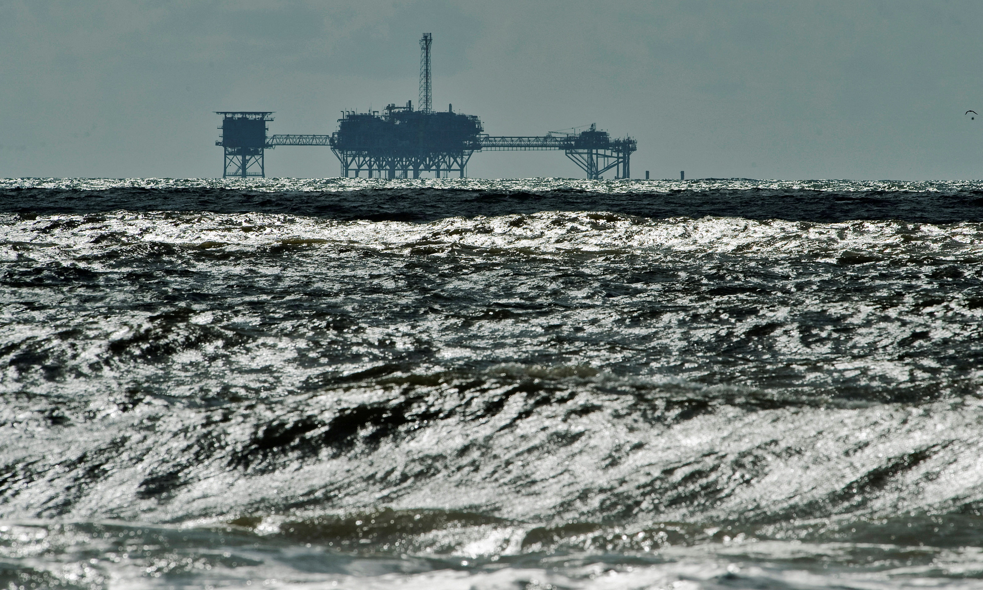 An oil and gas drilling platform stands offshore near Dauphin Island, Alabama