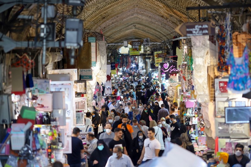 Iranians walk through Tehran Bazaar as coronavirus disease (COVID-19) cases spike, in Tehran