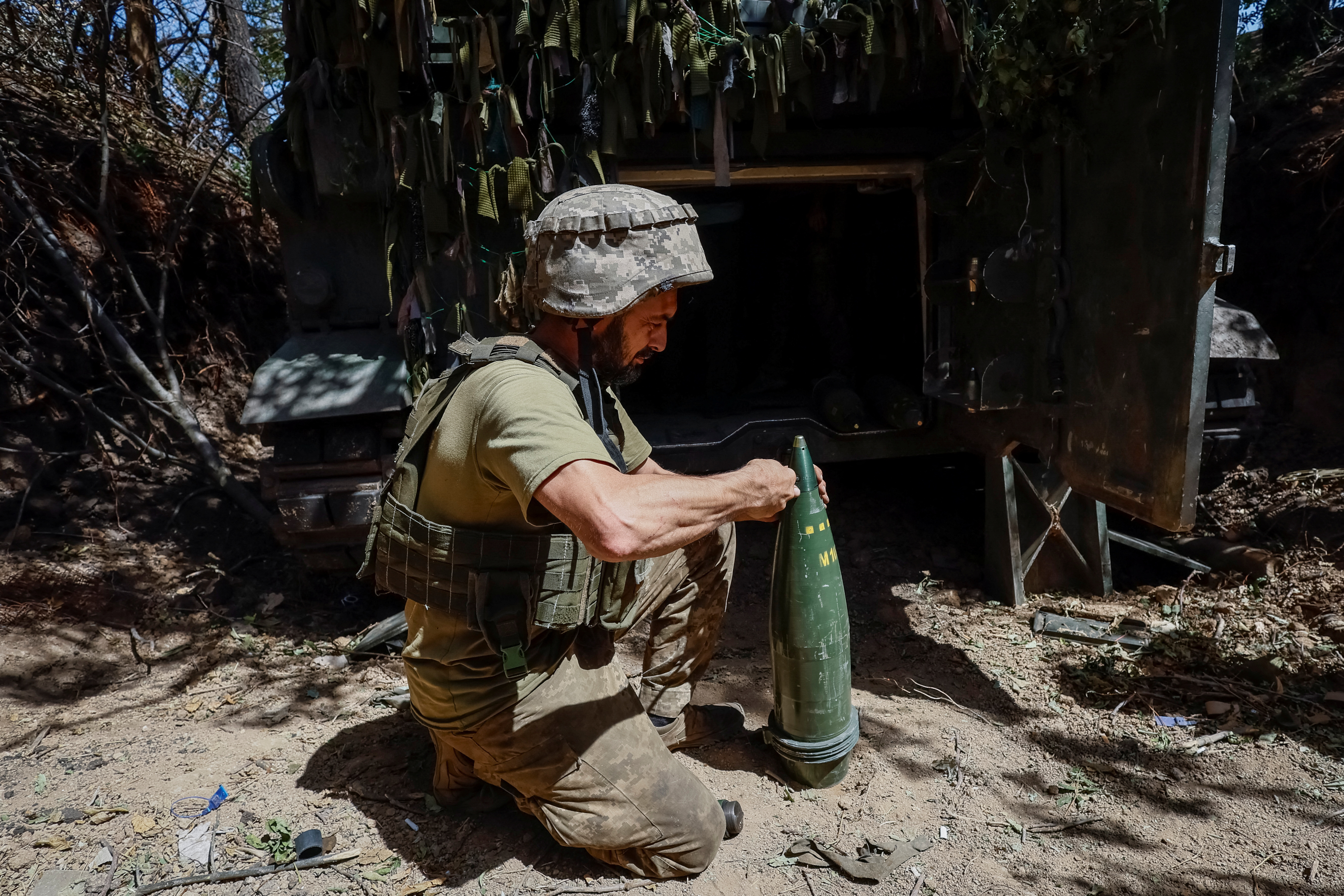 Ukrainian serviceman prepares a shell for an M109L self-propelled howitzer before firing towards Russian troops near a front line, in Donetsk region