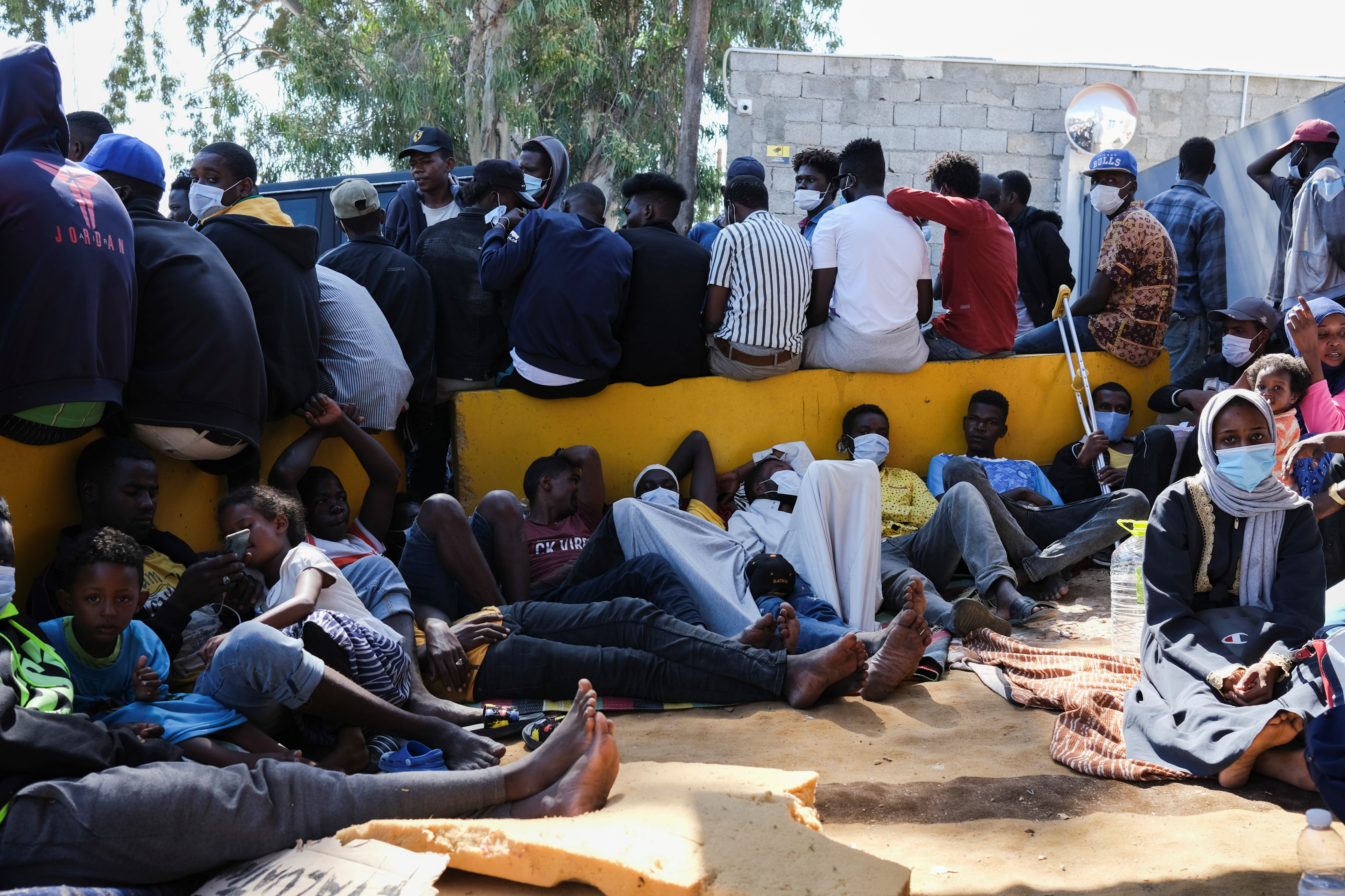 Migrants wait outside the United Nations High Commissioner for Refugees (UNHCR) negotiation office in Tripoli