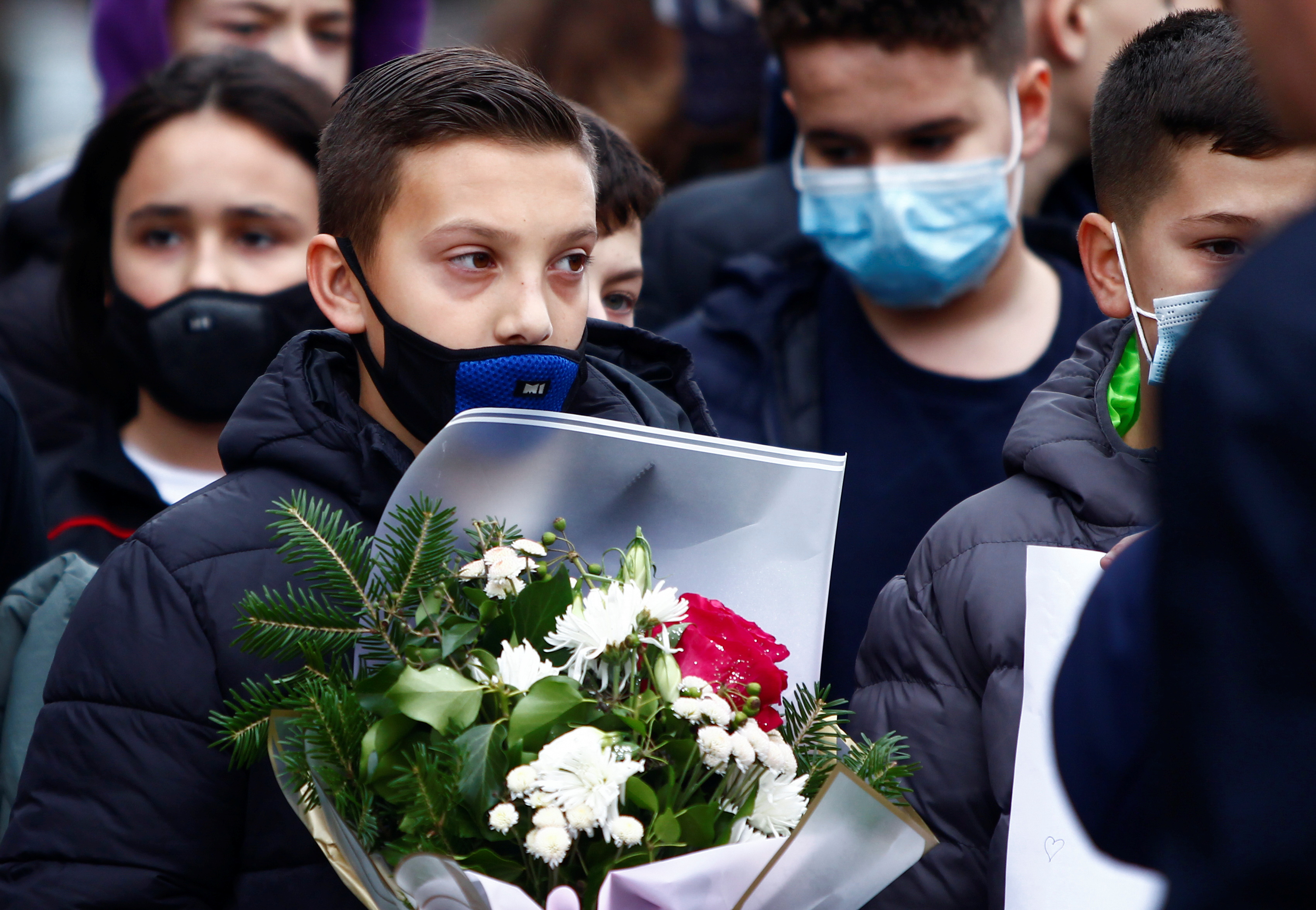 Pupils of the elementary school Ismail Qemali hold flowers to pay their respect to six of their friends and other victims of the bus crash in Bulgaria, in Skopje, North Macedonia, November 24, 2021. REUTERS/Ognen Teofilovski