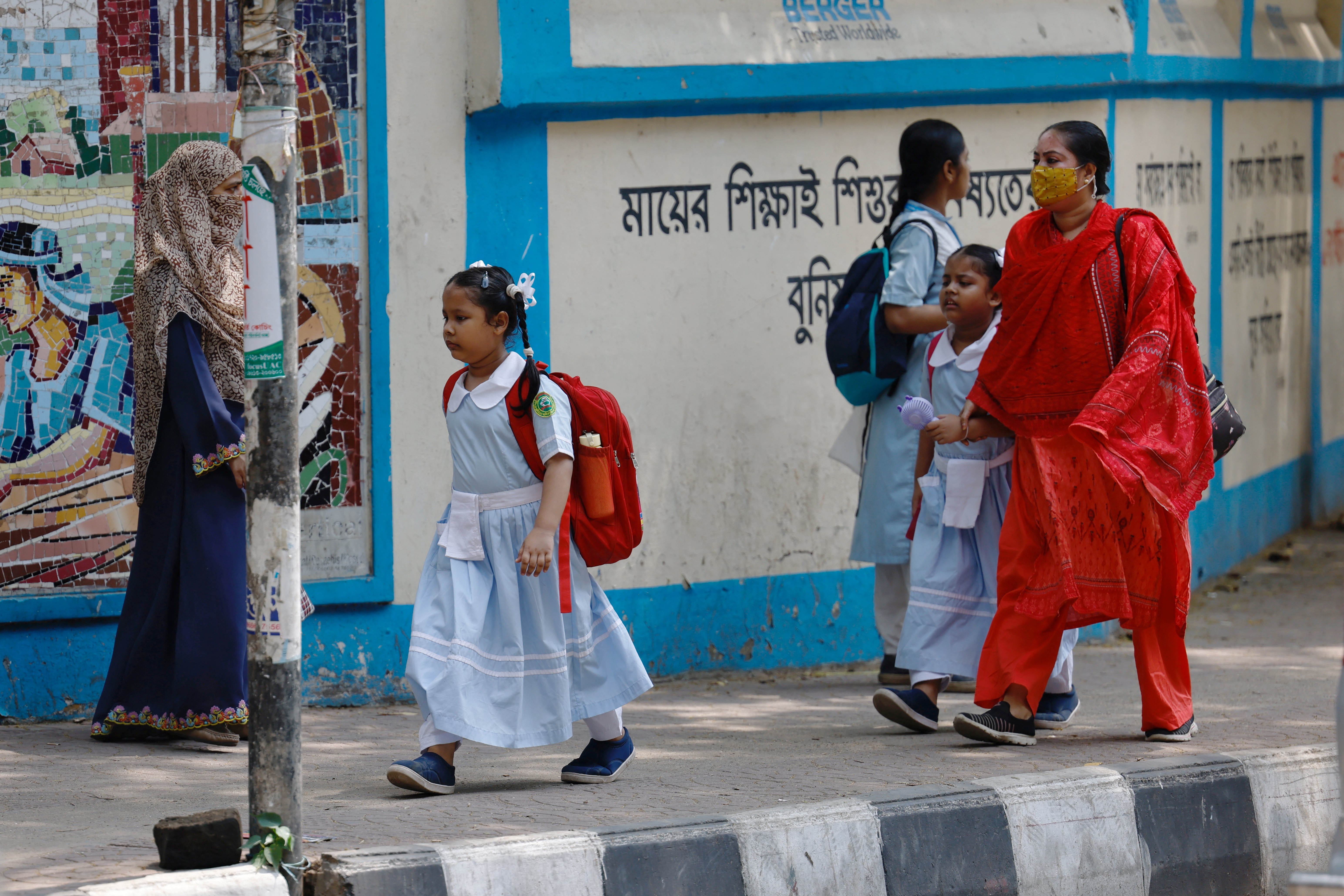 Children go to school as schools reopen after the fall in temperature, in Dhaka