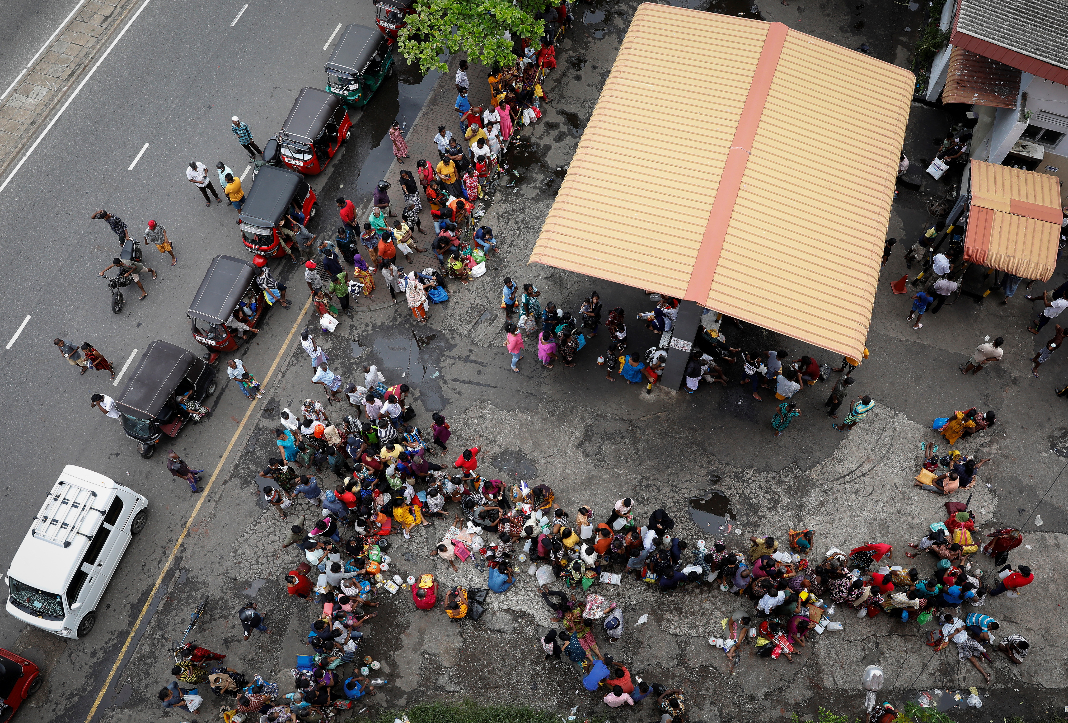 People wait in a queue to buy kerosene at a fuel station, amid the country's economic crisis in Colombo