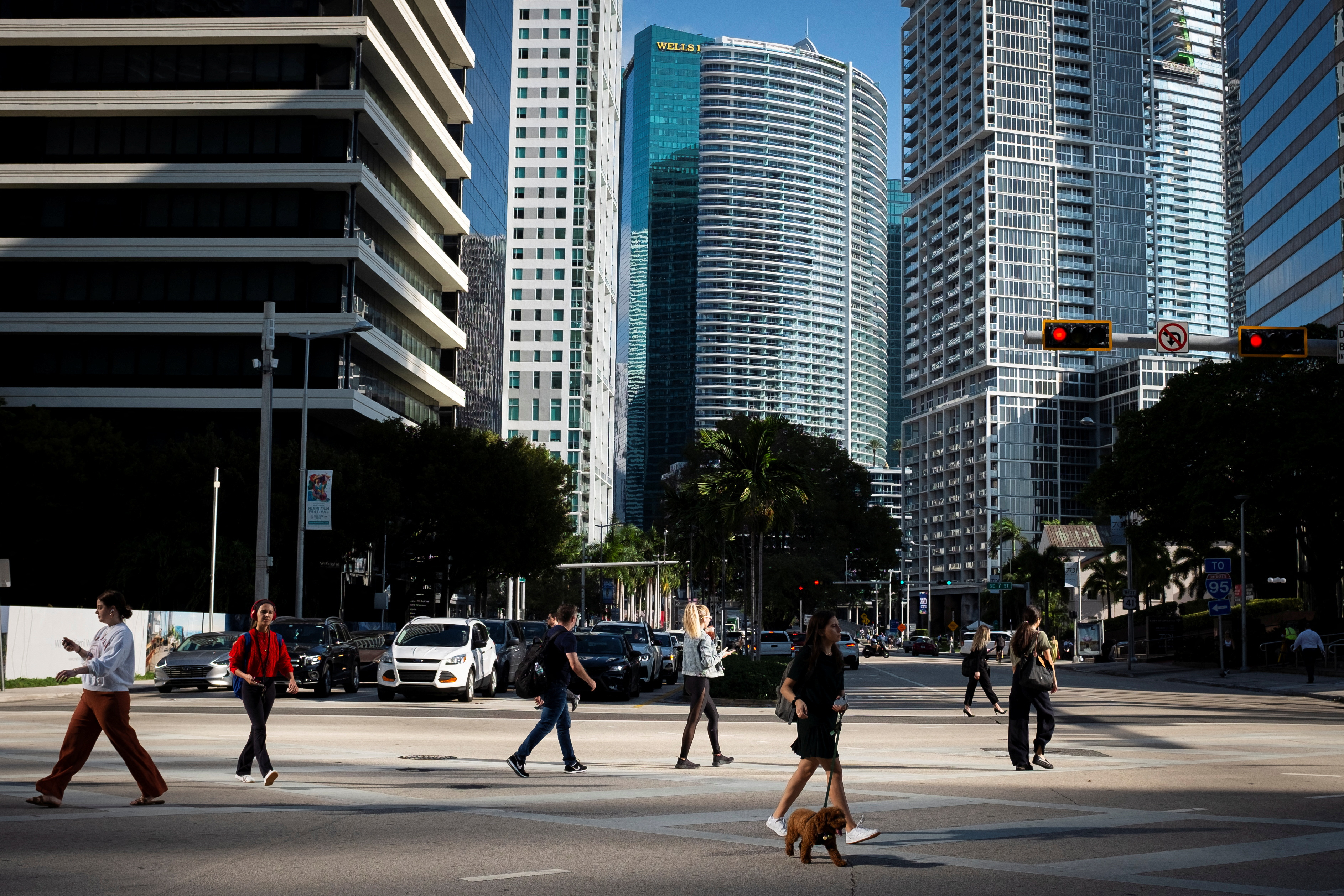 People cross the intersection of SW 8th Steet and Brickell Ave. at the Brickell neighborhood, known as the financial district, in Miami