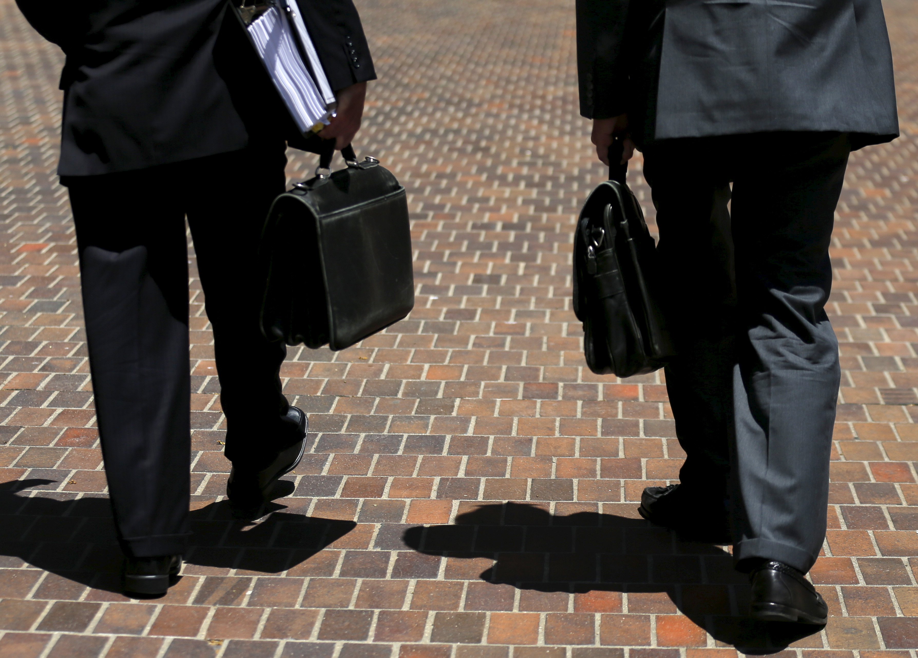 Lawyers walk with their briefcases towards the federal court house in San Diego, California