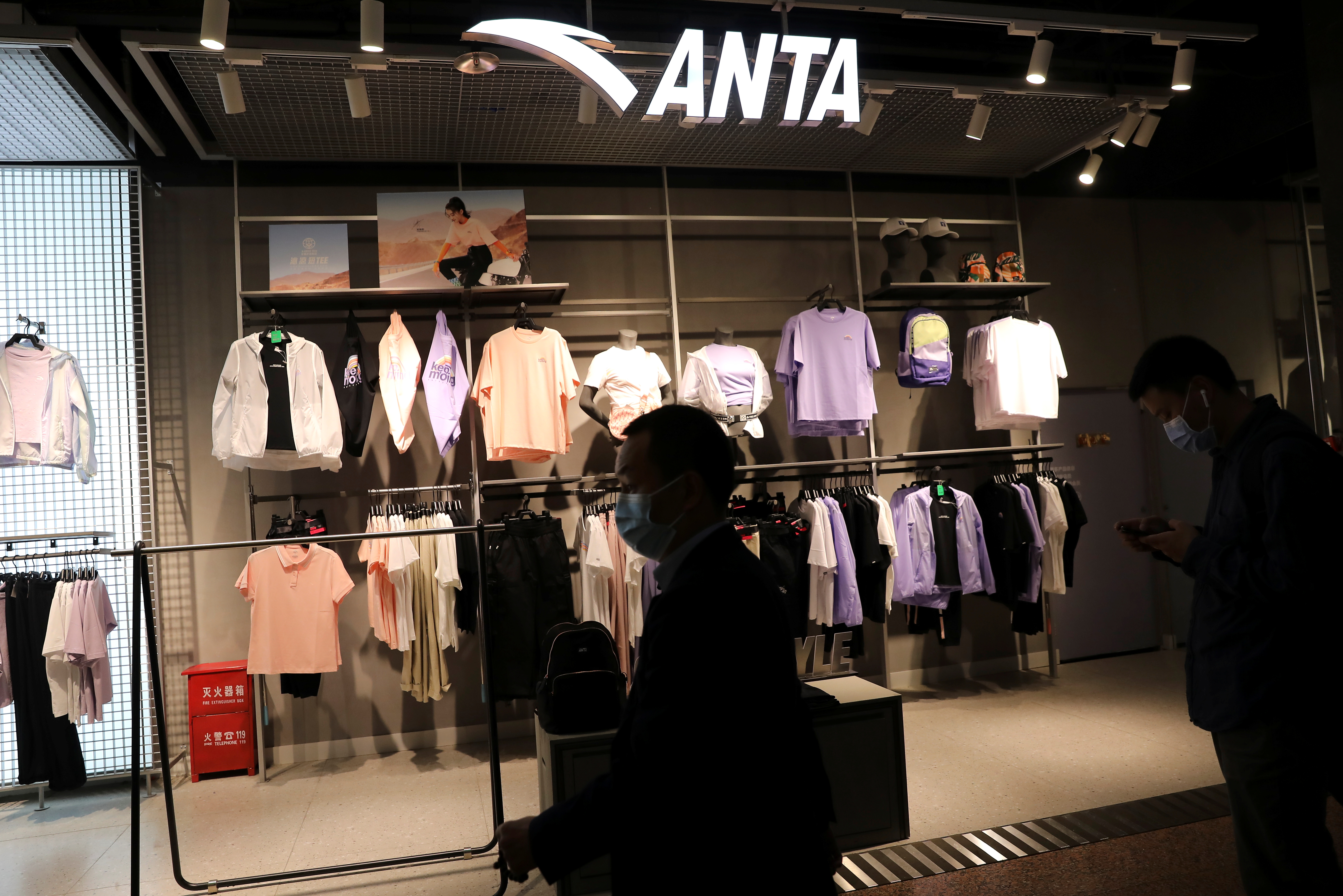 People walk past a store of Chinese sportswear brand Anta in Beijing, China April 15, 2021. Picture taken April 15, 2021. REUTERS/Tingshu Wang