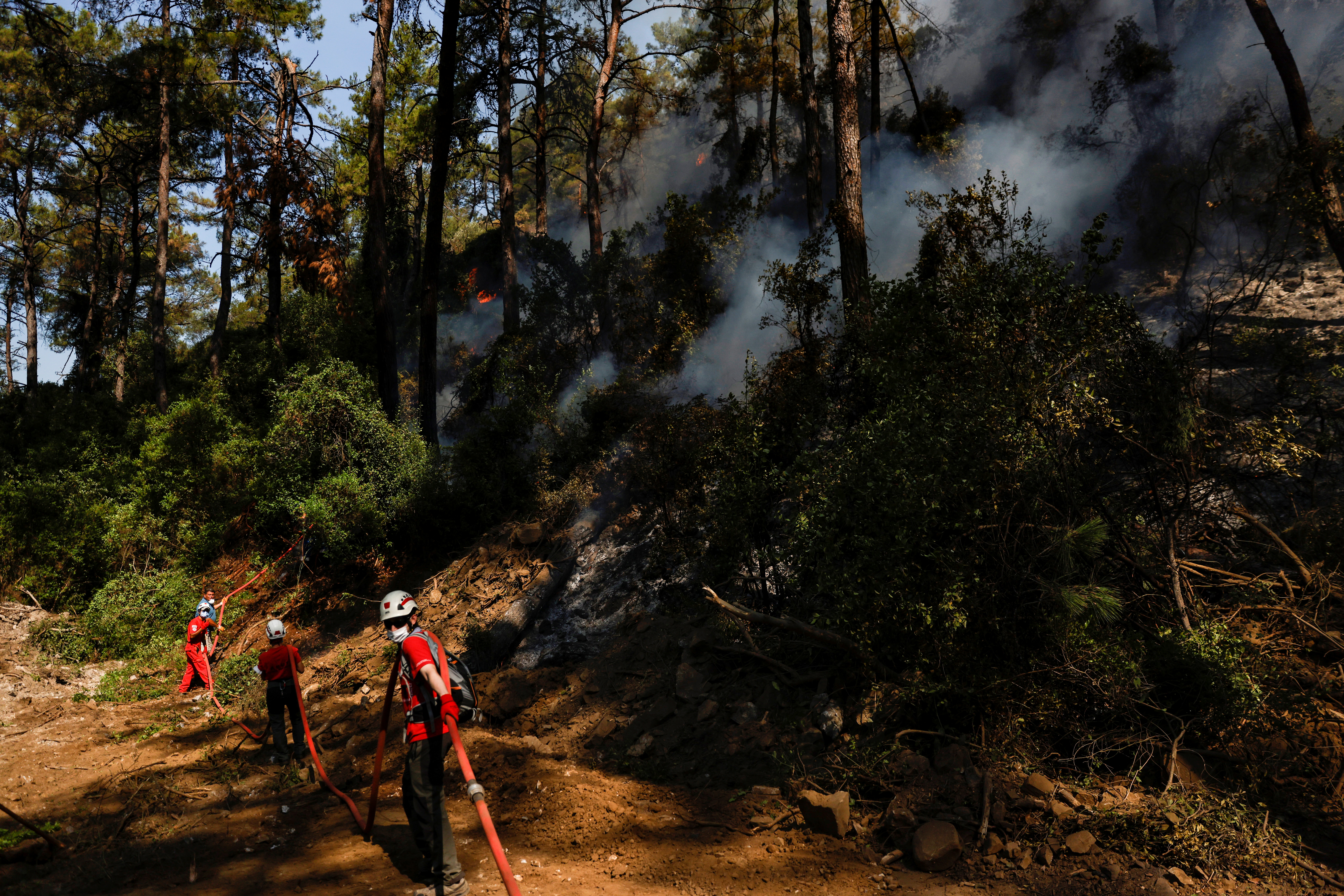 Firefighters and volunteers extinguish a wildfire near Marmaris, Turkey, August 2, 2021. REUTERS/Umit Bektas