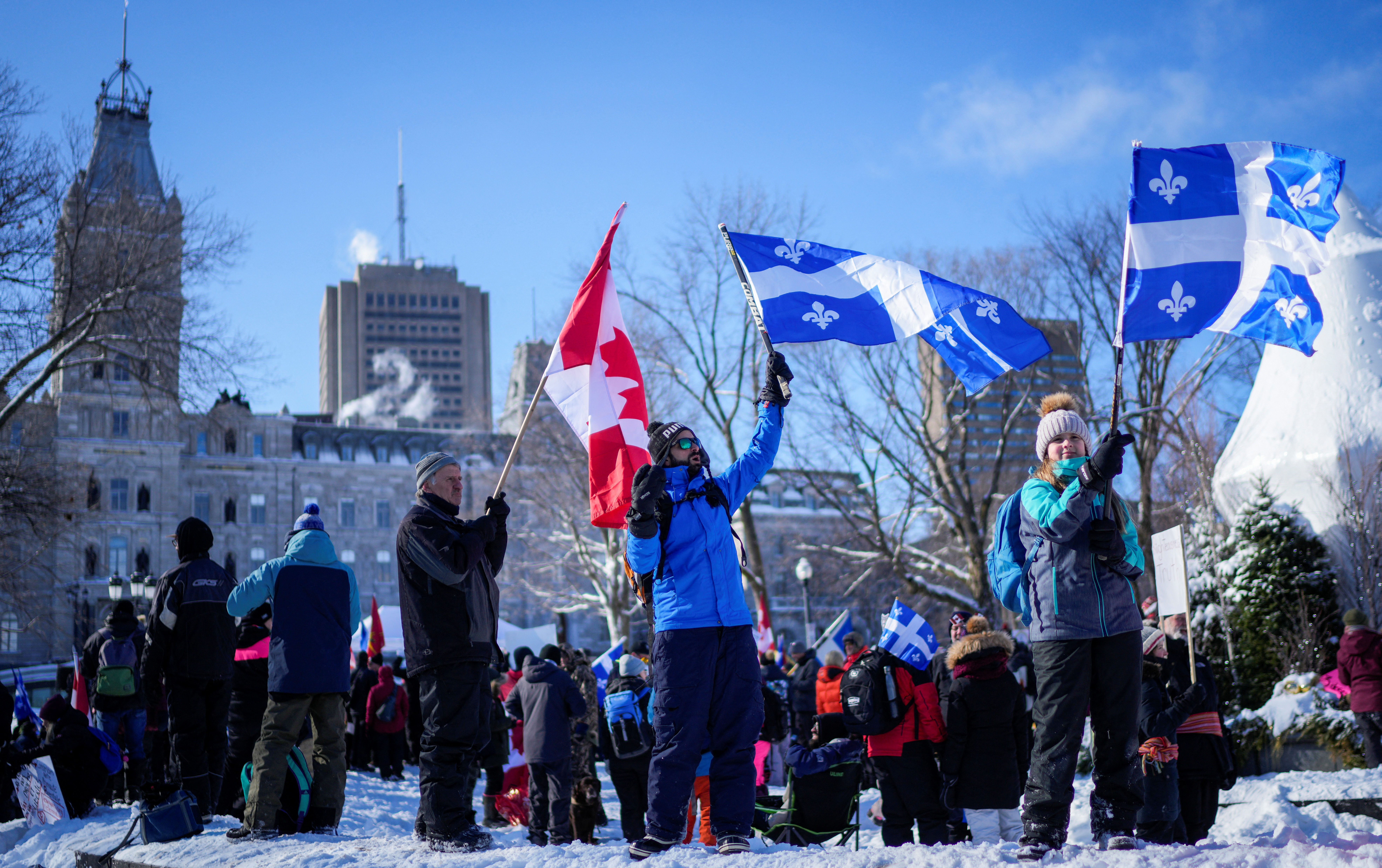 People wave flags near the National Assembly of Quebec, as truckers and their supporters protest against the coronavirus disease (COVID-19) vaccine mandates, in Quebec City, Canada February 5, 2022. REUTERS/Mathieu Belanger