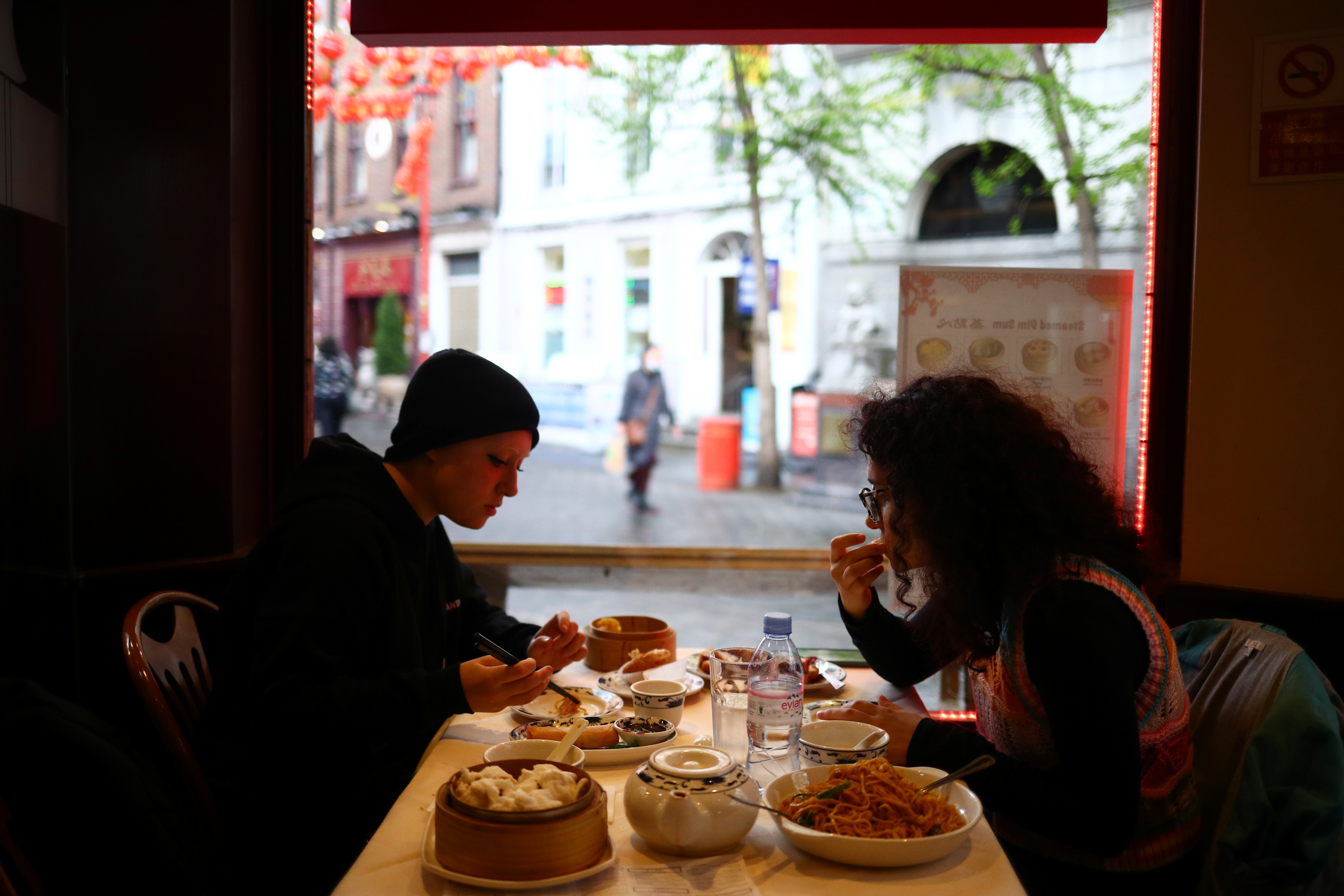 People sit inside a restaurant, amid the outbreak of the coronavirus disease (COVID-19), in Chinatown, London, Britain, 18 May 2021. REUTERS/Hannah McKay