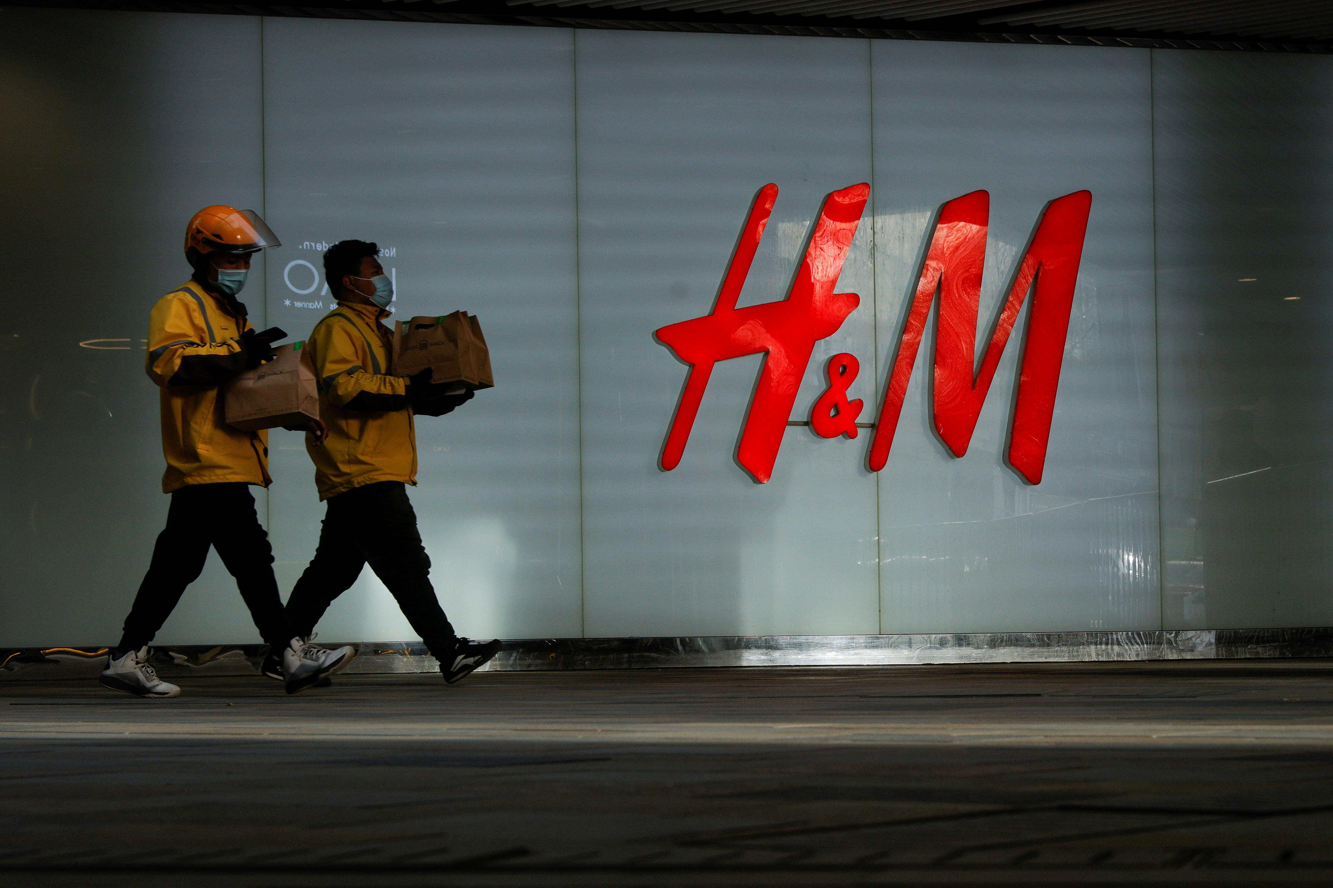 People walk past an H&M store in a shopping area in Beijing