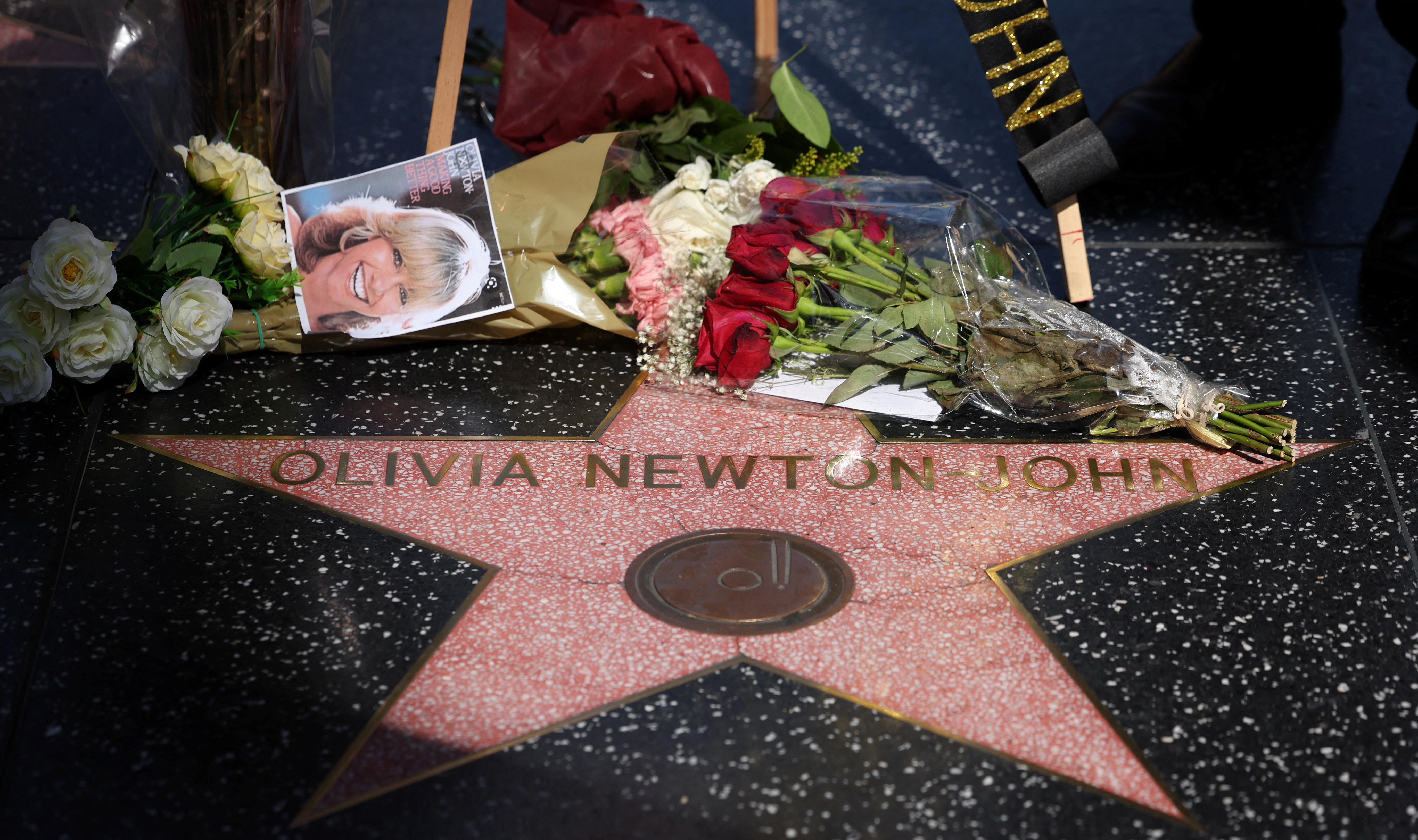 The star of late actor Olivia Newton-John is pictured adorned with flowers and photographs on the Hollywood Walk of Fame in Los Angeles