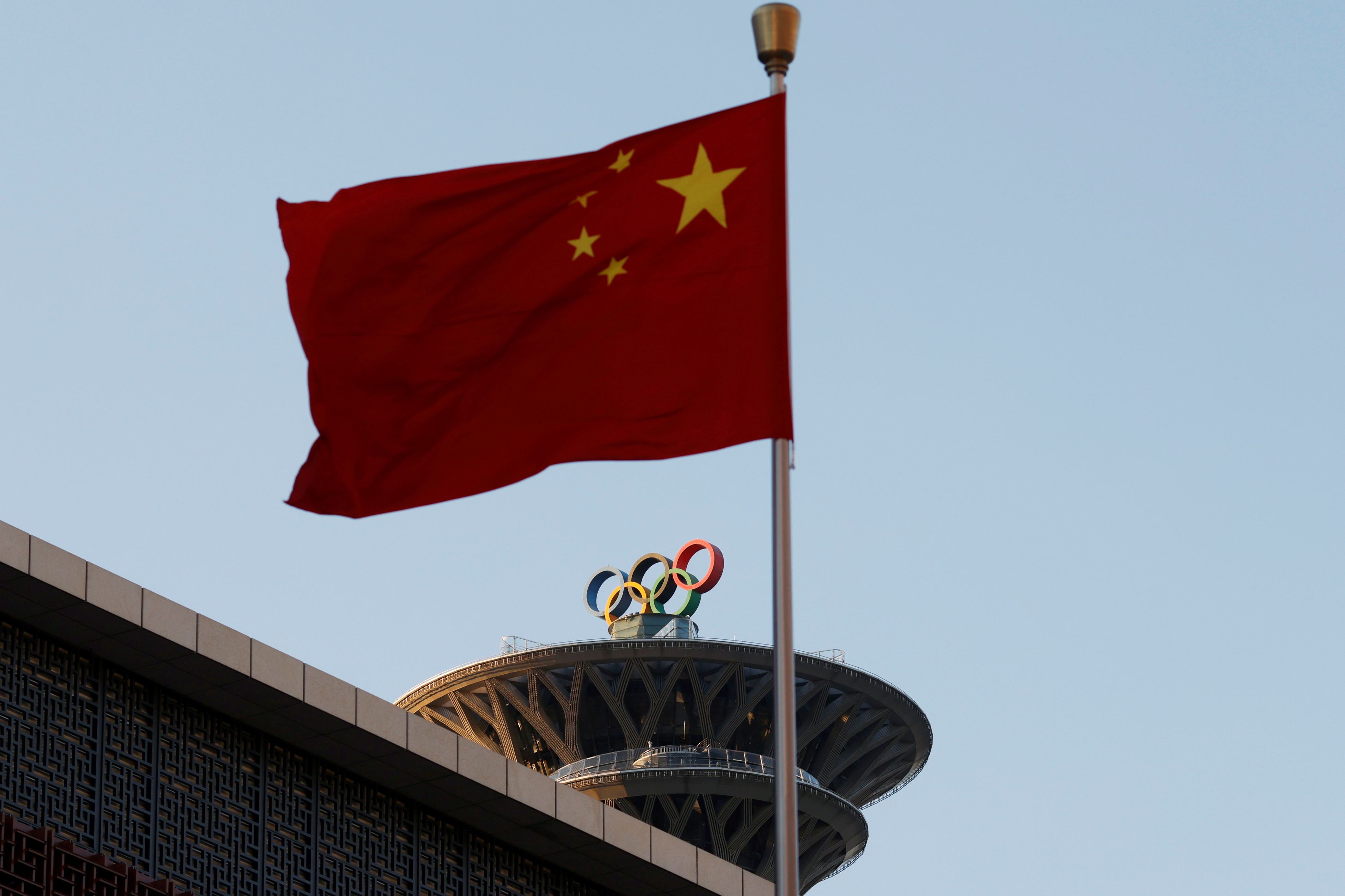 Chinese flag flutters near the Olympic rings on the Olympic Tower in Beijing