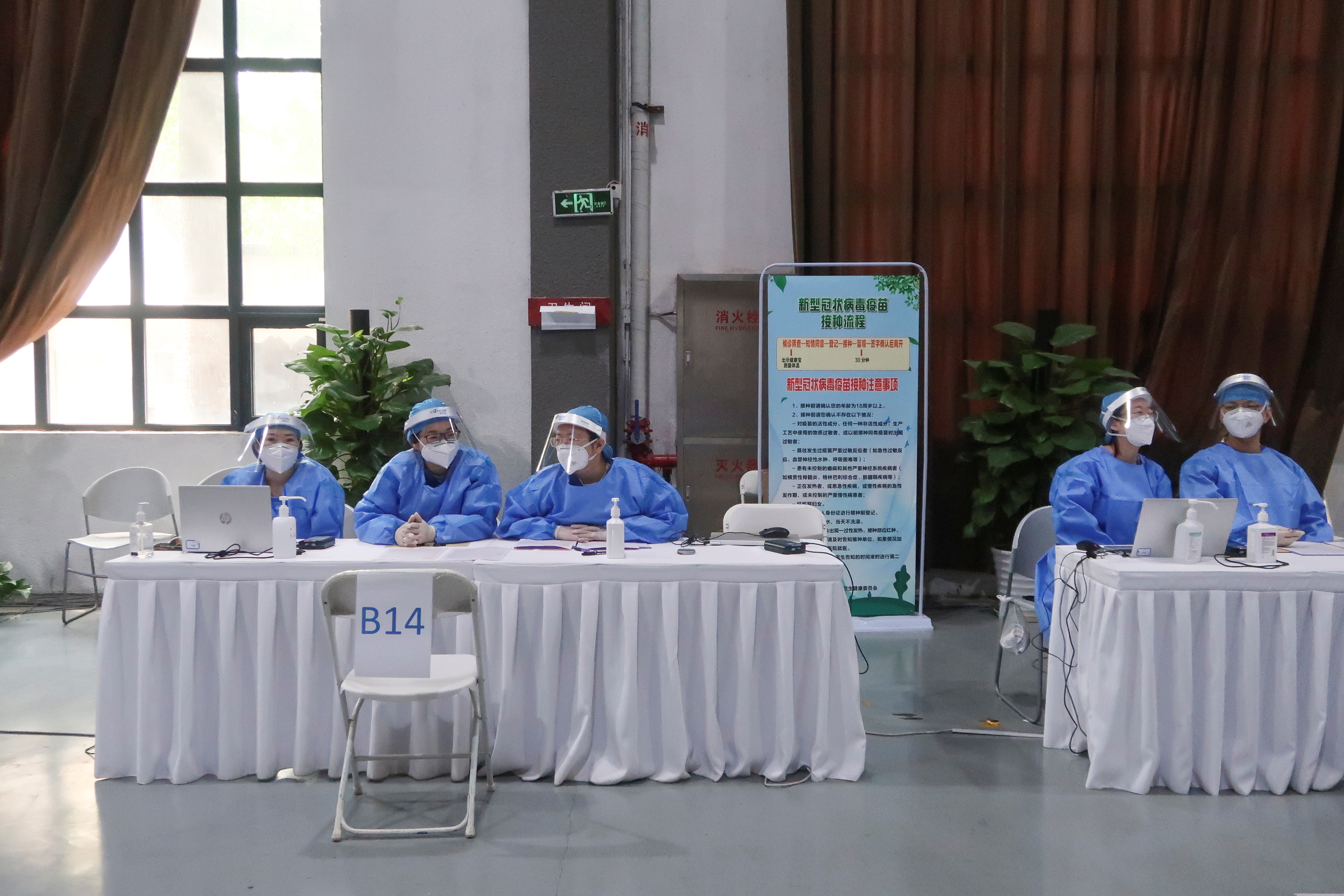 Staff members sit at desks to register people for a shot of a vaccine against the coronavirus disease (COVID-19) at a vaccination center, during a government-organized visit, in Beijing, China, April 15, 2021.  REUTERS/Thomas Peter