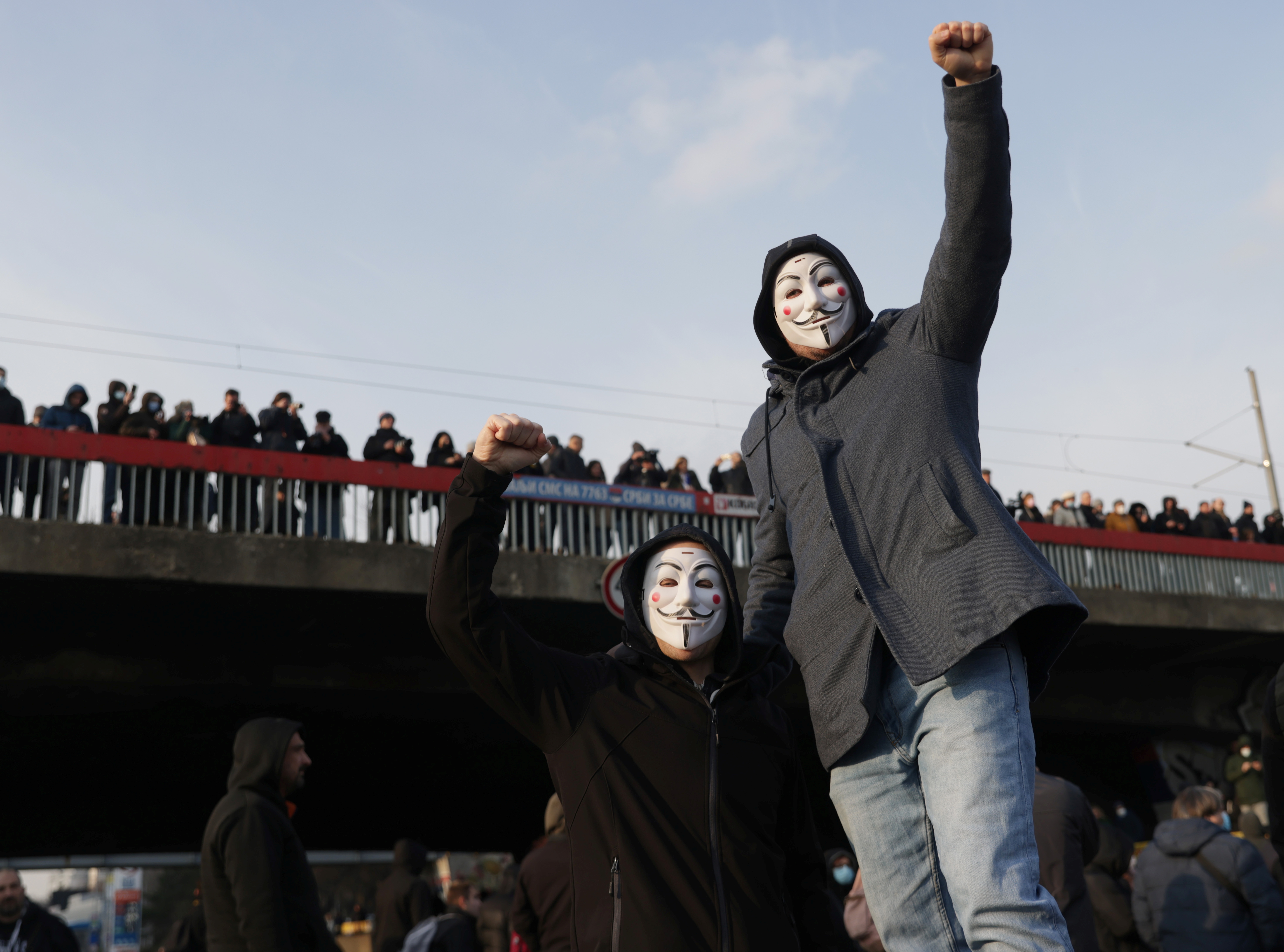 Anti-government protesters wear masks during a protest in Belgrade