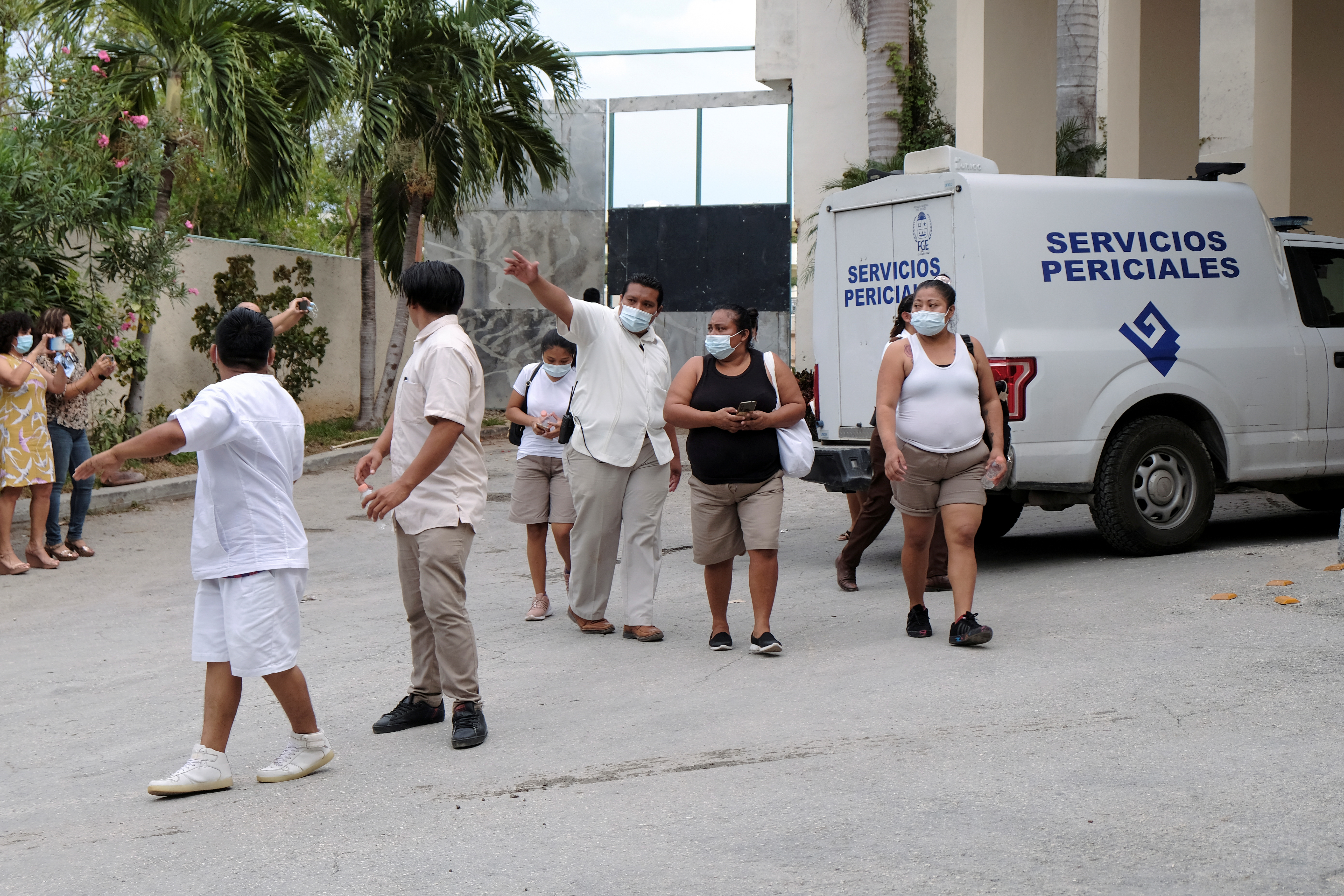 Hotel workers are seen at the entrance to a hotel after two suspected drug gang members were shot dead in a beachfront clash between rival groups near the Mexican resort of Cancun, in Puerto Morelos, Mexico November 4, 2021. REUTERS/Paola Chiomante 