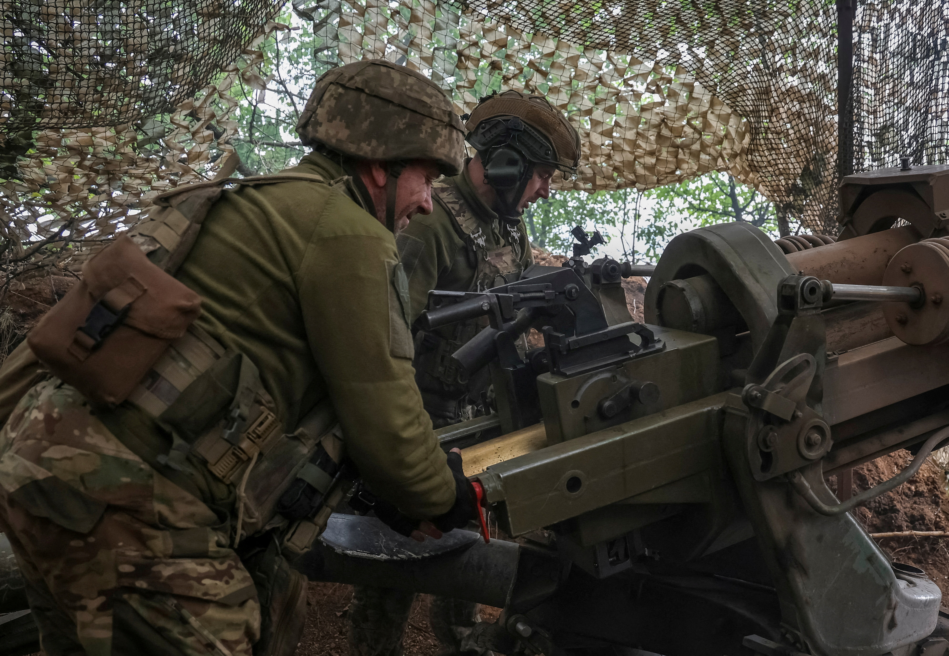 Ukrainian service members fire a L119 howitzer in Donetsk region