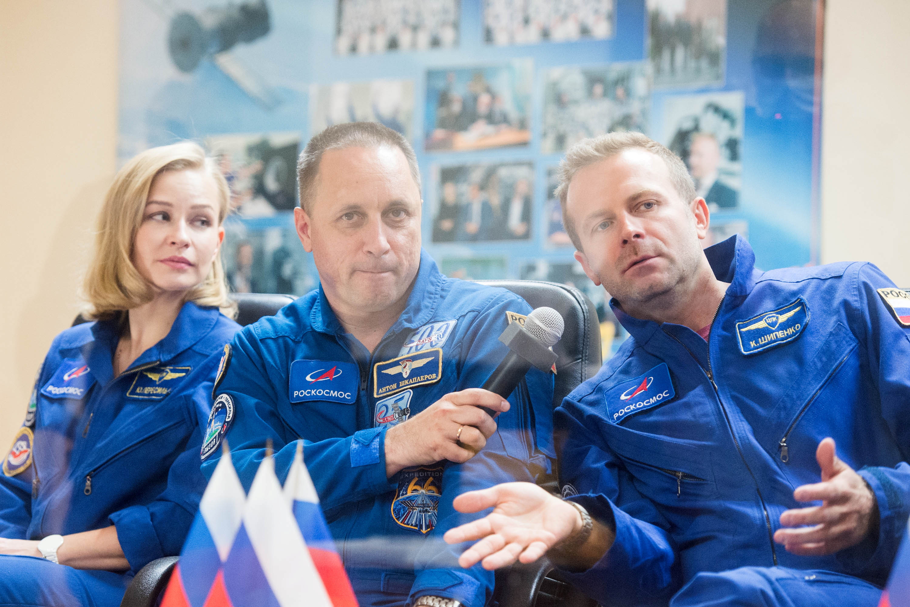 Crew members, cosmonaut Anton Shkaplerov, actress Yulia Peresild and film director Klim Shipenko, answer questions behind a glass wall during a news conference ahead of the expedition to the International Space Station (ISS) at the Baikonur Cosmodrome, Kazakhstan October 4, 2021. The launch is scheduled for October 5, 2021. Andrey Shelepin/GCTC/Roscosmos/Handout via REUTERS  
