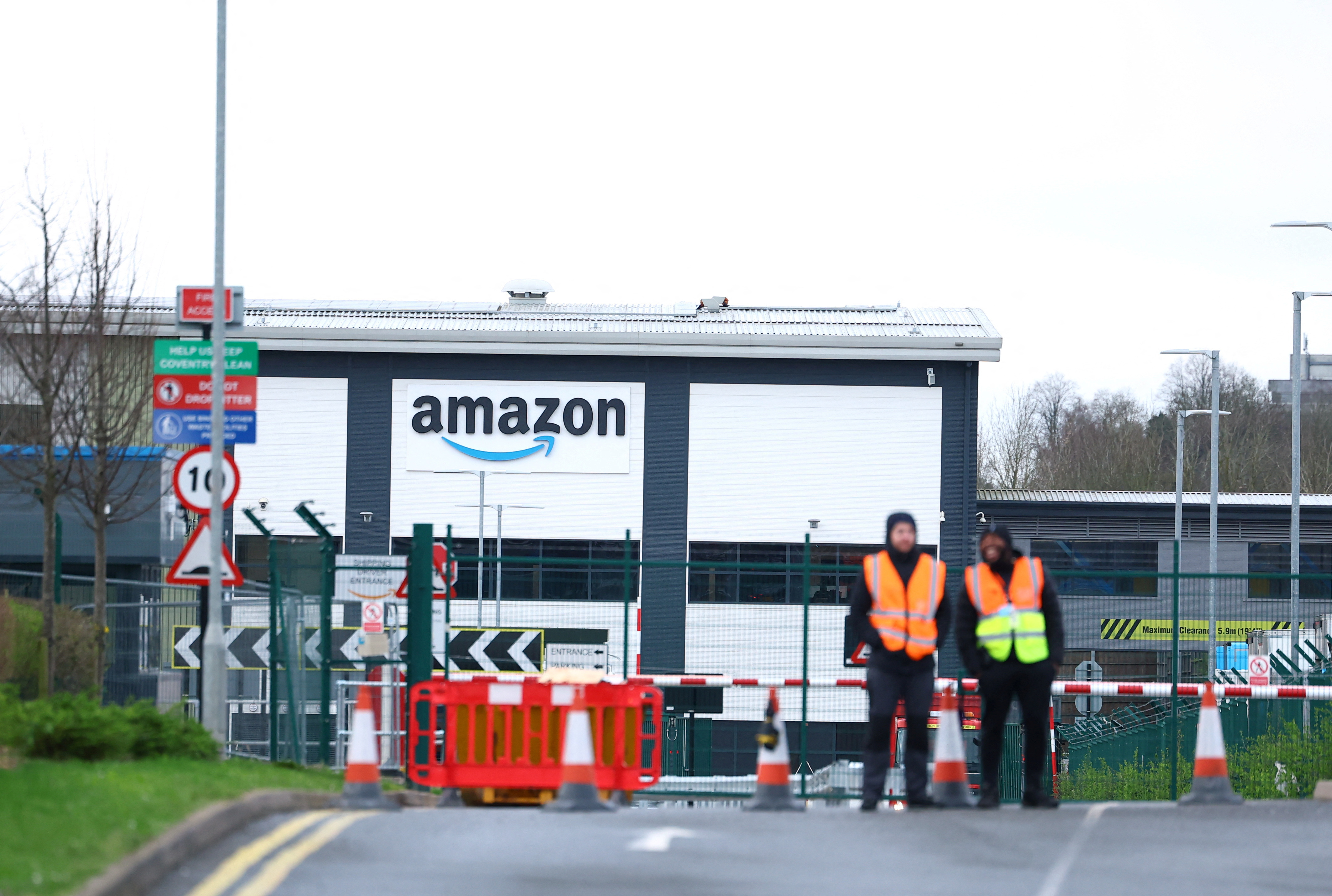 Security is seen during industrial action outside the Amazon warehouse