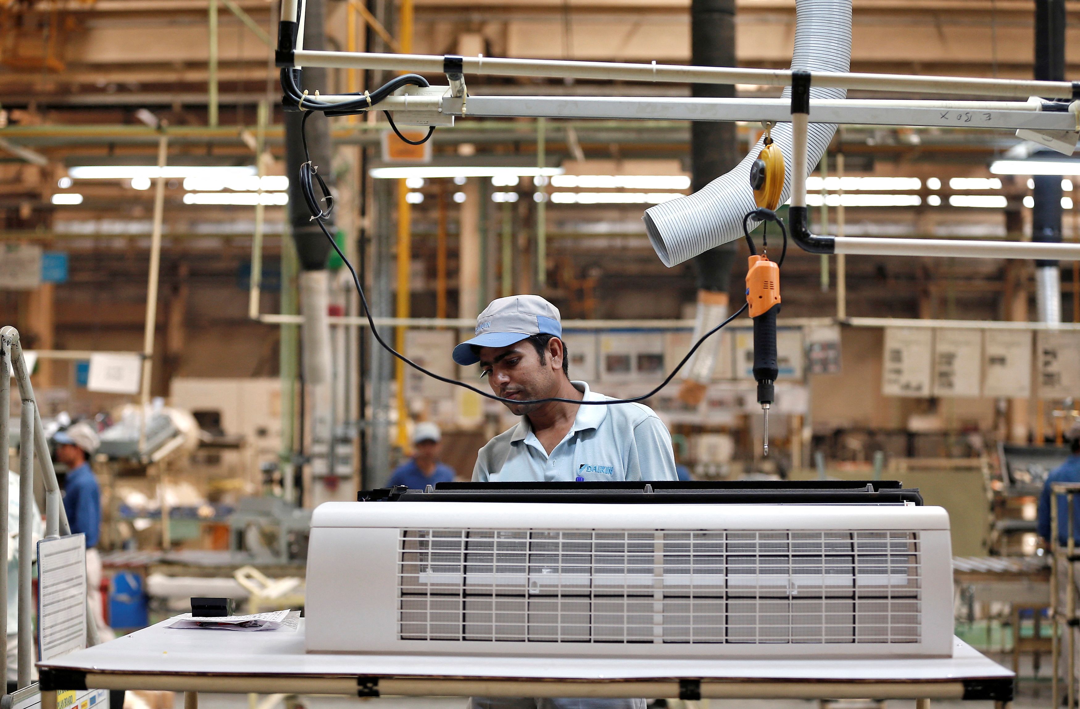 Worker assembles an air conditioner inside the Daikin Industries Ltd. plant at Neemrana in Rajasthan