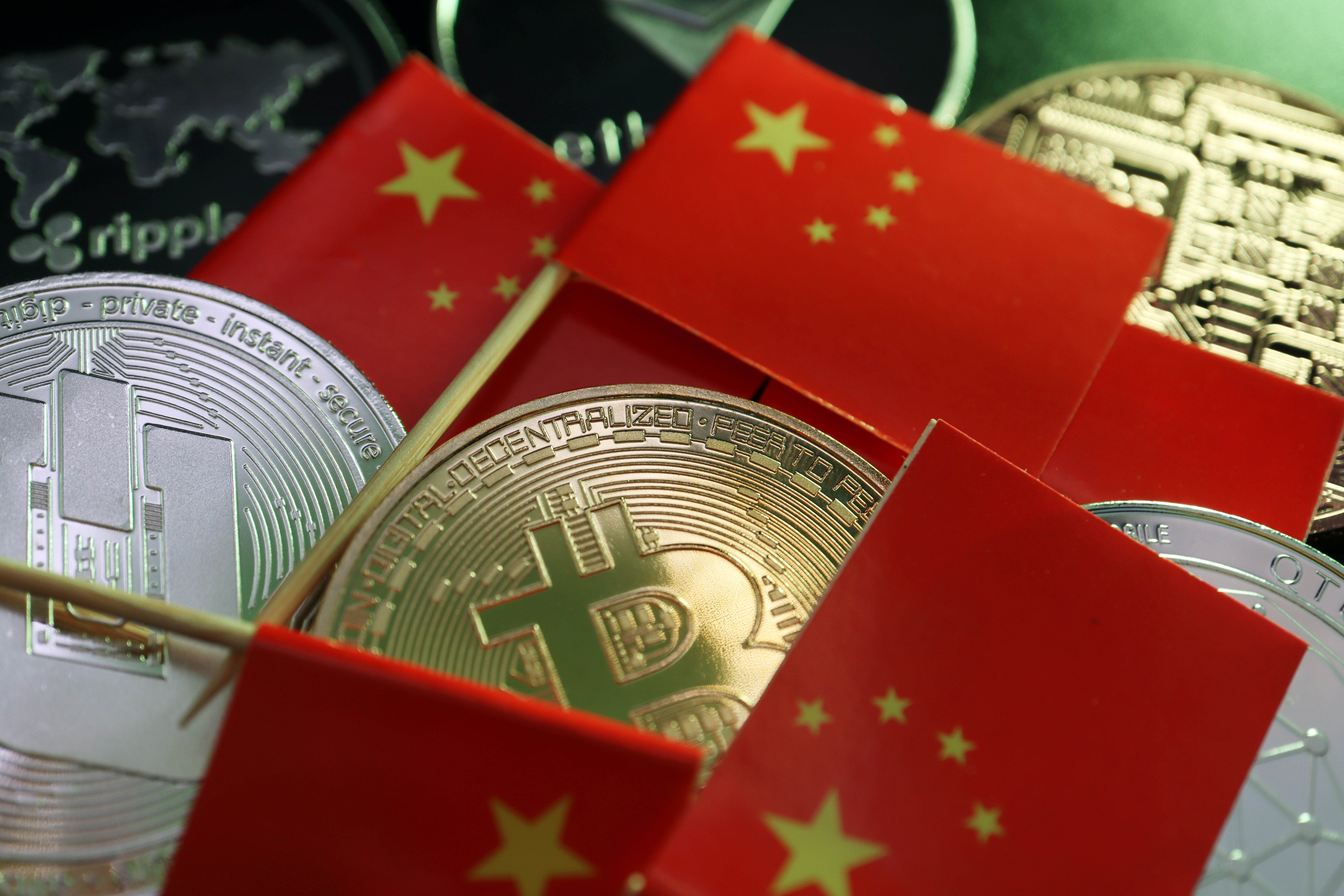 Chinese flags are seen among representations of Bitcoin, Dash, Ripple, Ethereum and other cryptocurrencies in this illustration picture taken June 2, 2021. REUTERS/Florence Lo/Illustration 