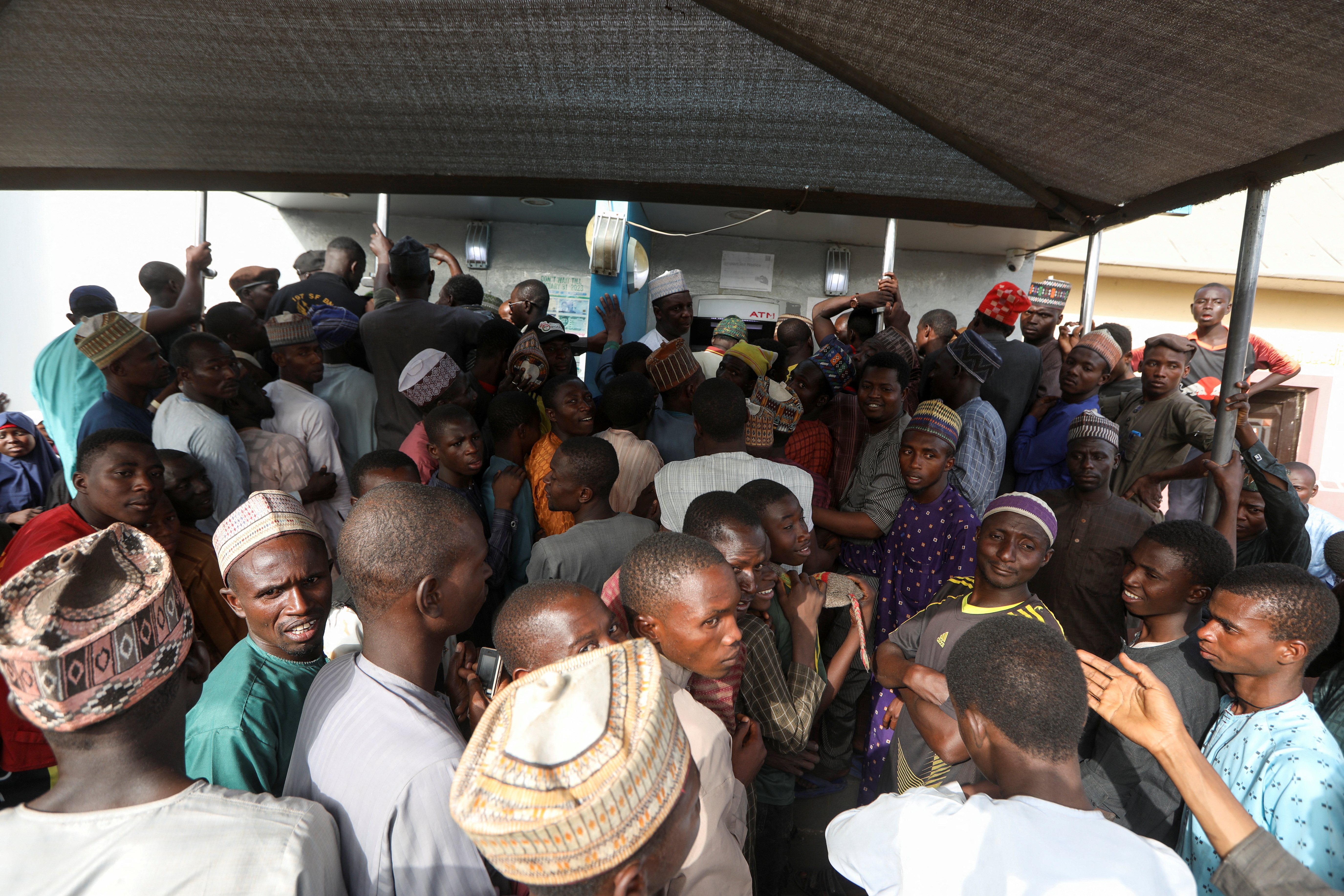 People queue to withdraw cash from an ATM at a bank, ahead of presidential elections, in Zamfara
