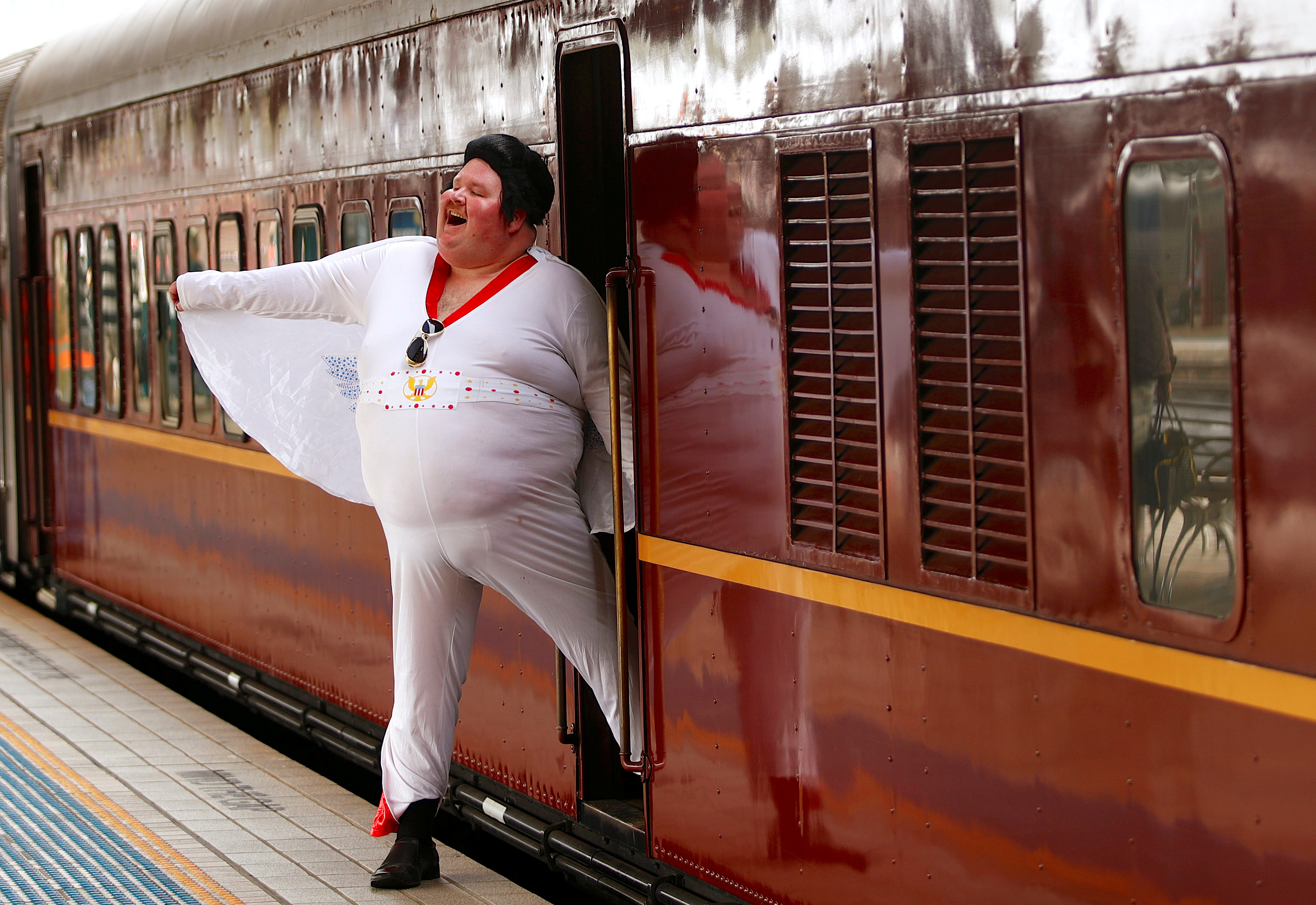 Elvis Presley impersonator Wright poses next to the Elvis Express train at Sydney's Central station before it departs for the 26th annual Elvis Festival