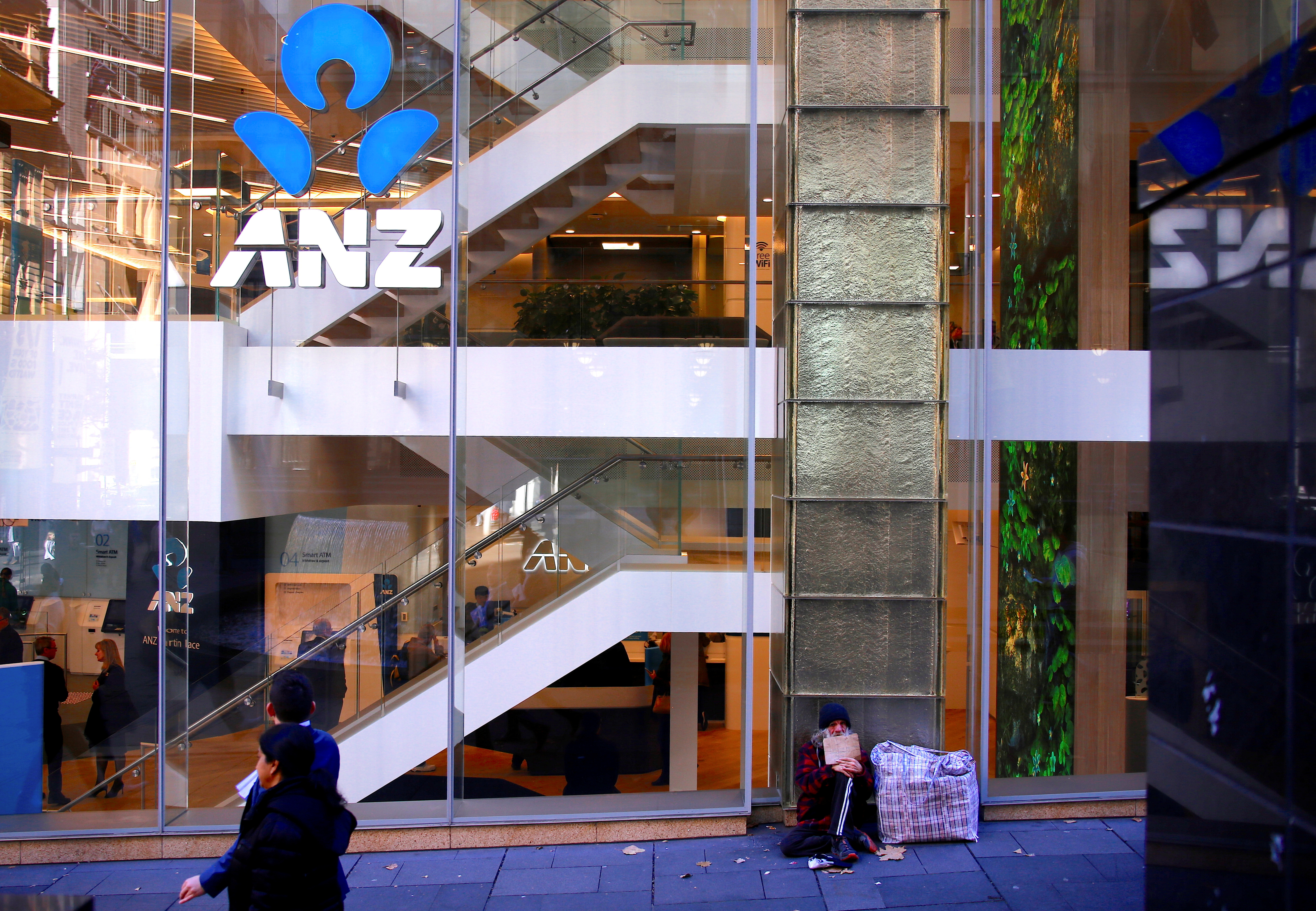 A man who says he is homeless for over 30 years begs for money as he sits outside a branch of the ANZ Banking Group in central Sydney, Australia