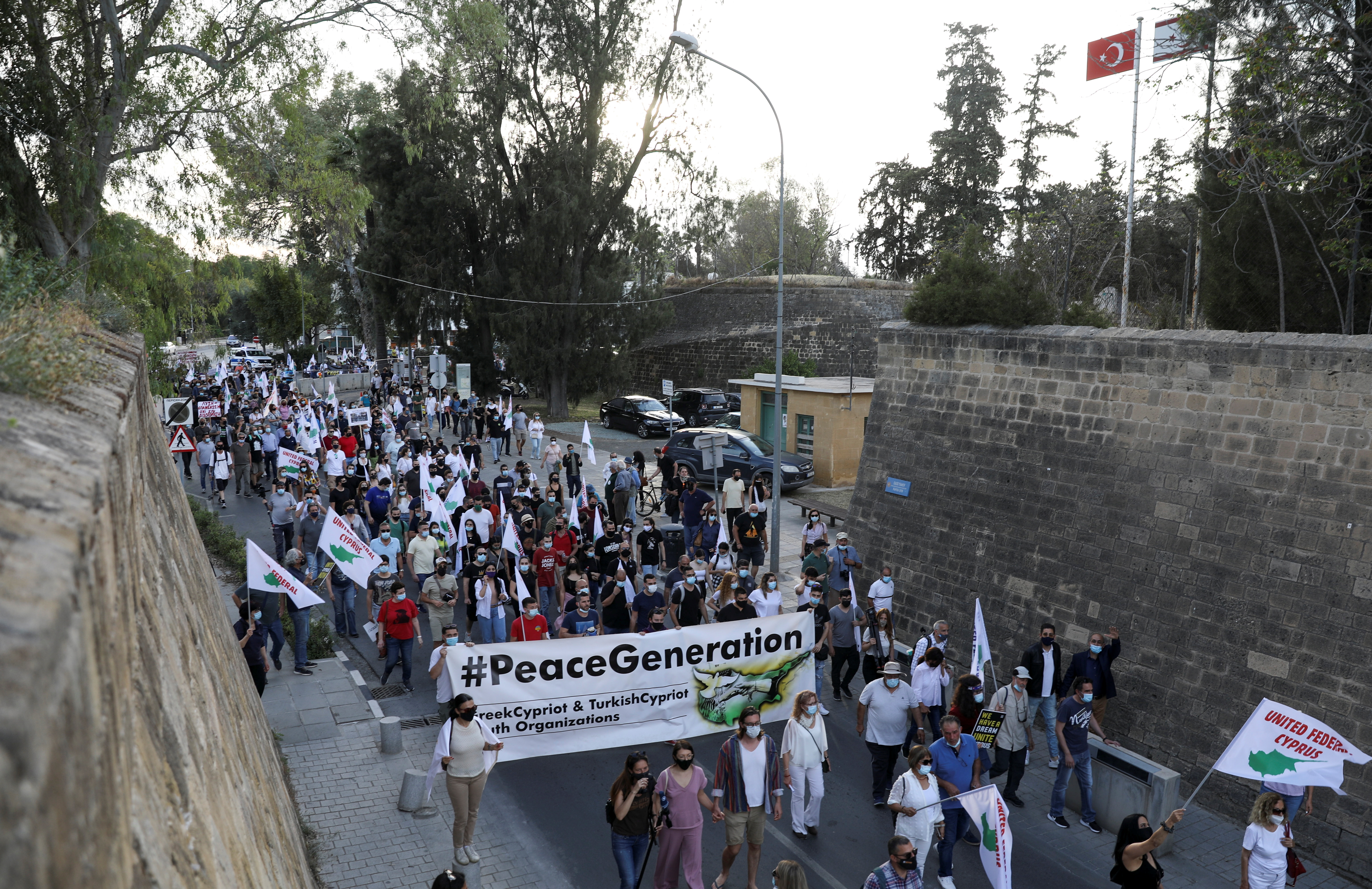 Grekcyprioter marscherar fredligt under ett återföreningssamling längs de medeltida murarna som omger den delade huvudstaden Nicosia, Cypern den 24 april 2021. REUTERS / Yiannis Kourtoglou